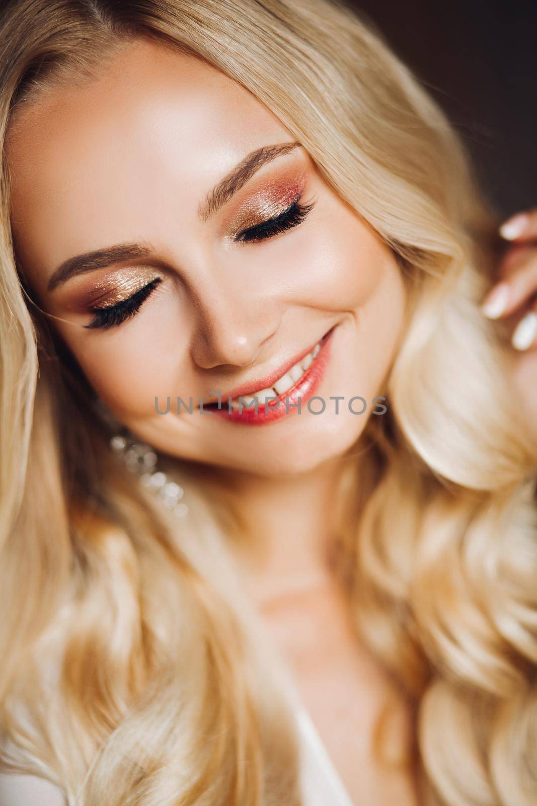 Portrait from above of charming smiling young blondie, looking at camera. Beautiful sexy lady with pure skin, long hair and light make up posing. Concept of style, fashion.