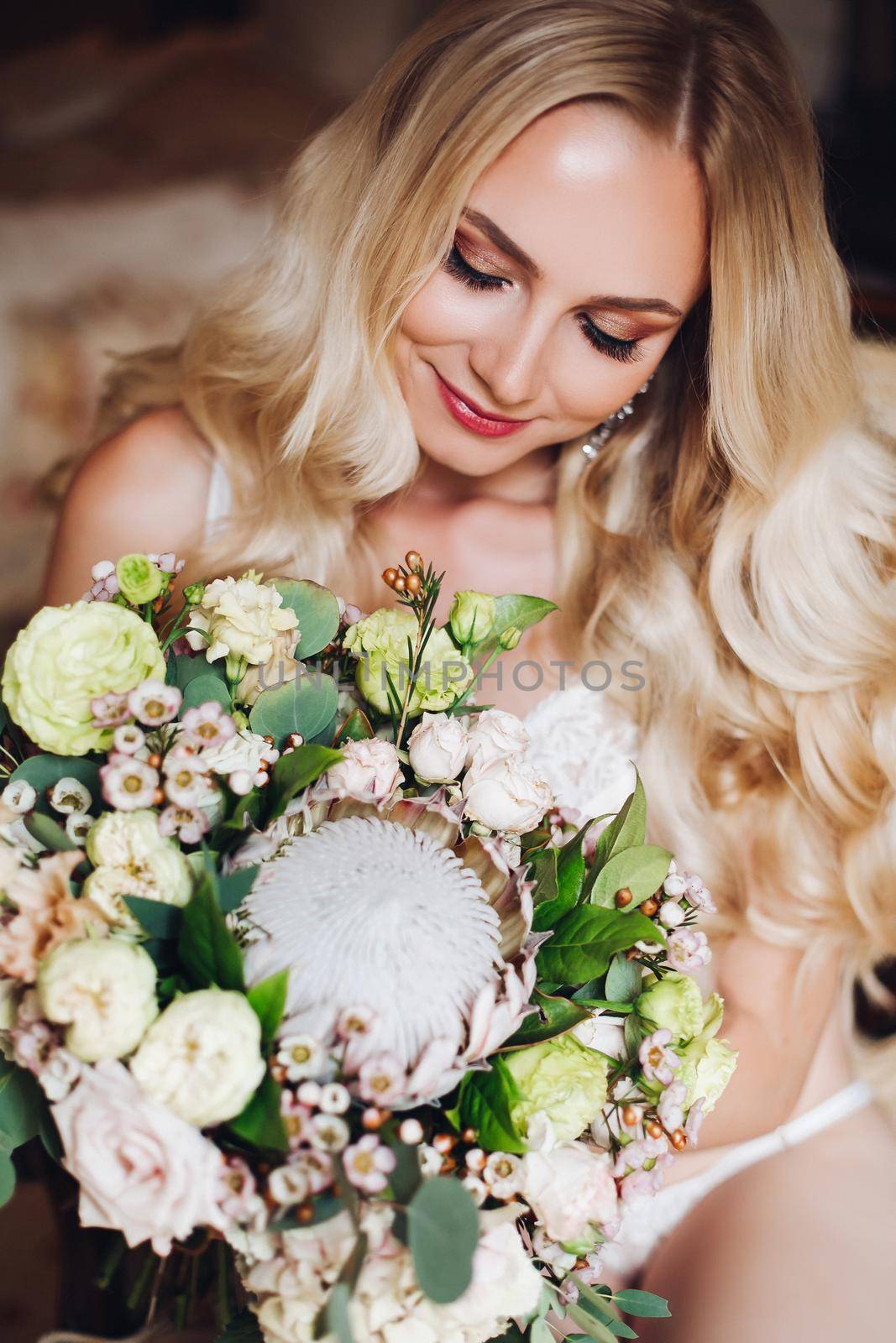 Pretty bride holding wedding bouquet and posing with closed eyes. by StudioLucky