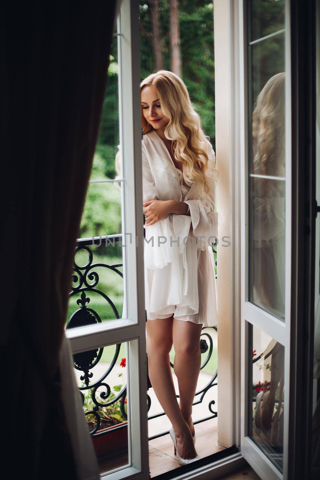 Gorgeous blondie bride walking at balcony and waiting for her groom. by StudioLucky