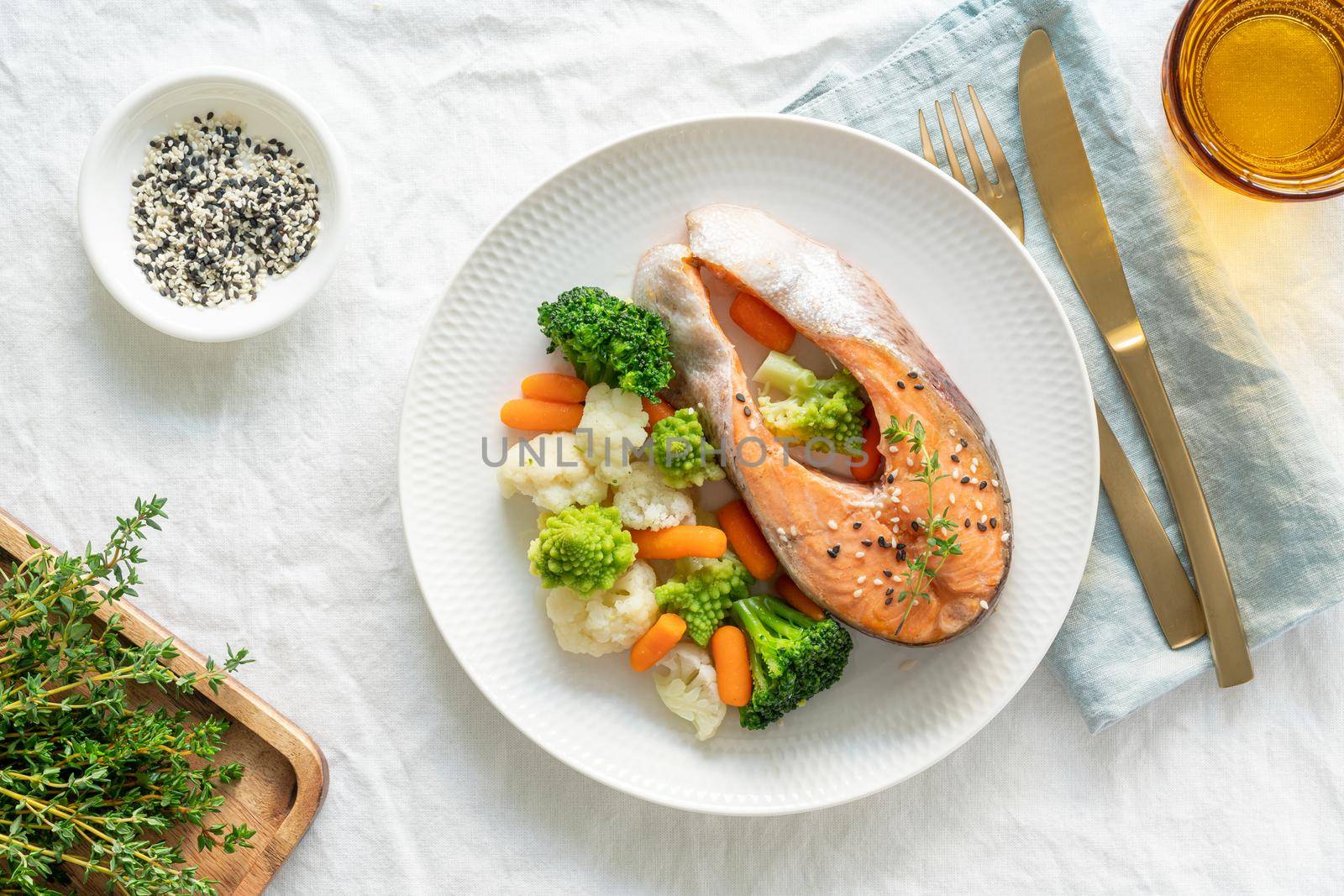 Steam salmon and vegetables, top view. Paleo, keto, fodmap, dash diet. Mediterranean diet with steamed fish. Healthy concept, white plate on gray table, gluten free, lectine free