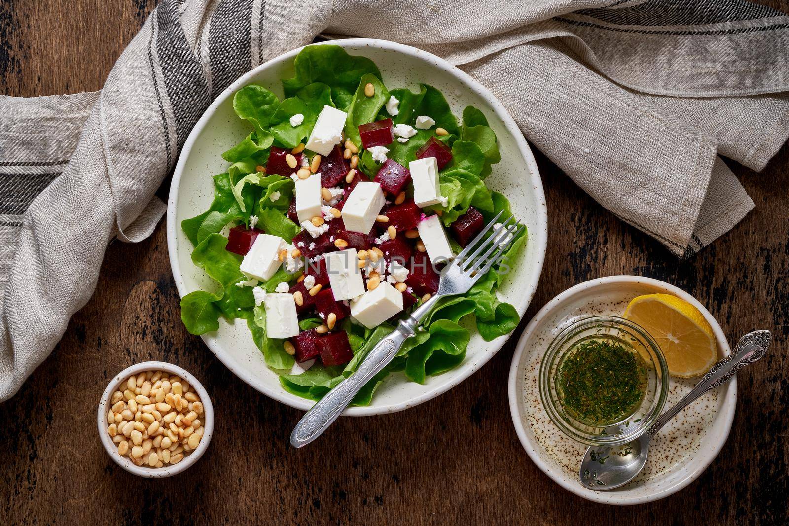 Healthy salad with beet, curd, feta and pine nuts, lettuce. Low carb keto ketogenic dash diet. Dark food photography. Top view