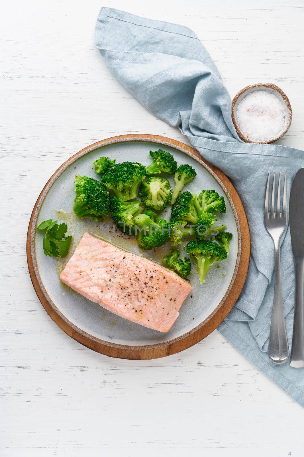 Steam salmon and vegetables, broccoli, paleo, keto, lshf or dash diet. Mediterranean, Clean eating, balanced food. Gray ceramic plate on white table, vertical