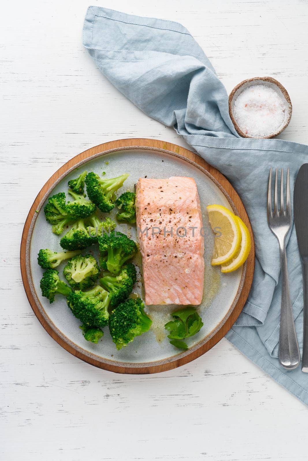 Steam salmon, broccoli, paleo, keto, lshf or dash diet. Mediterranean, Clean eating, balanced food. Gray ceramic plate on white table, vertical