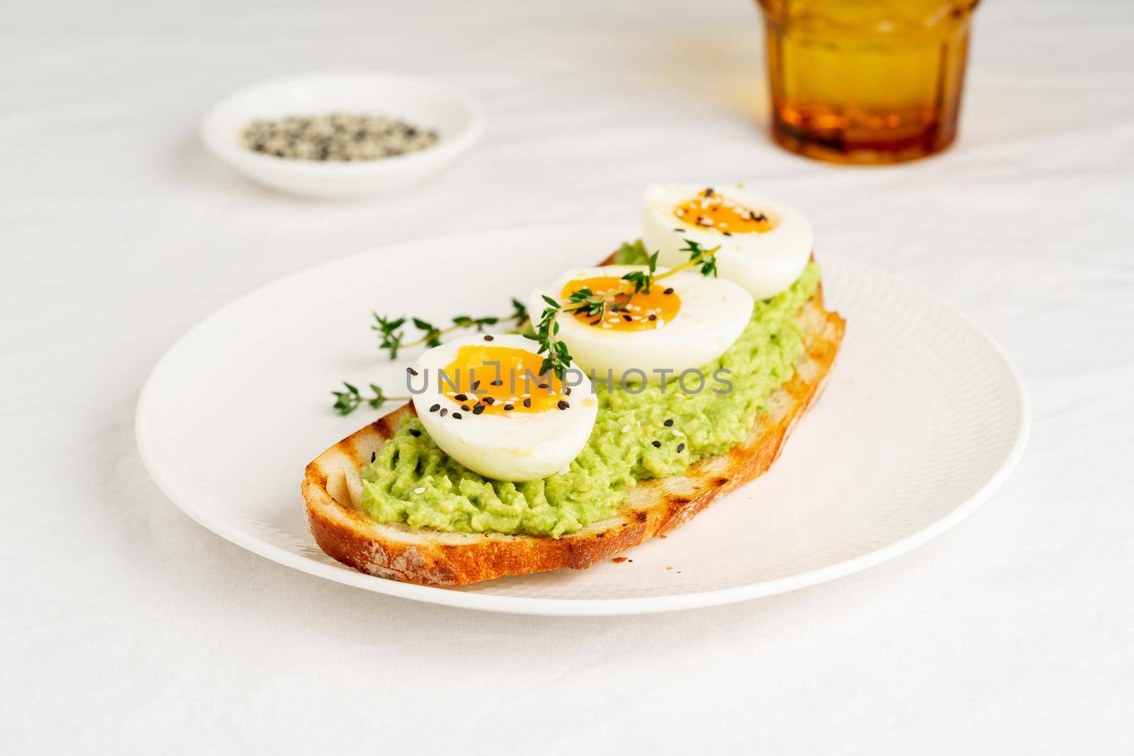 Avocado toast with toasted bread soft-boiled eggs with herbs by NataBene