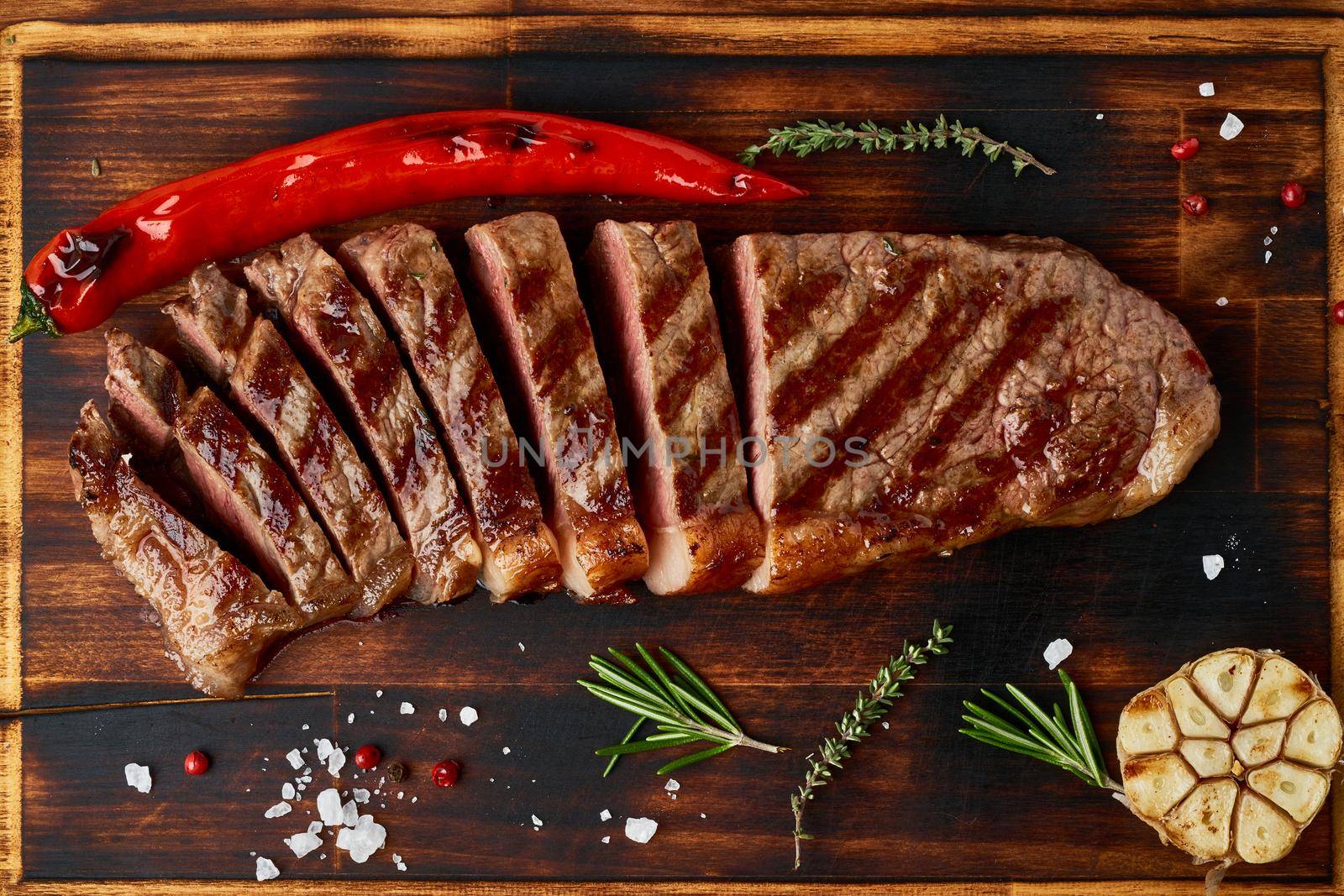Keto ketogenic diet medium beef steak, grilled striploin on cutting board. Paleo food by NataBene