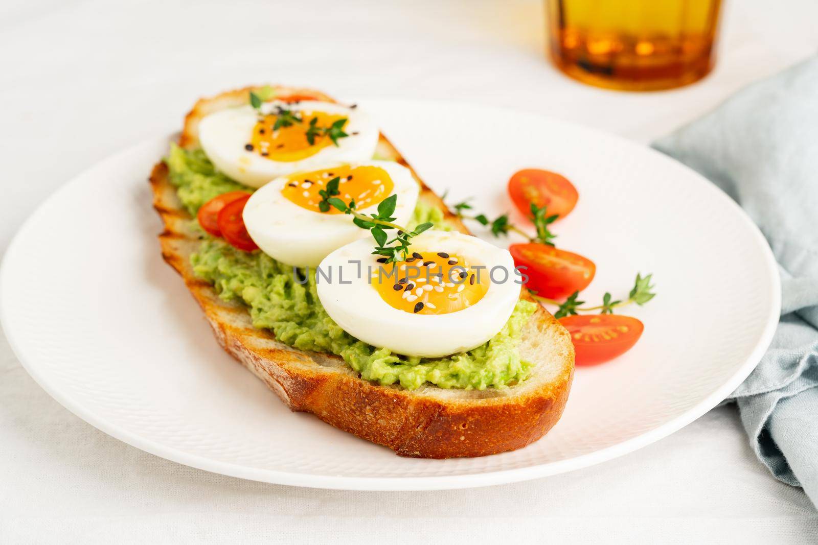 Avocado toast with toasted bread soft-boiled eggs with tomatoes by NataBene