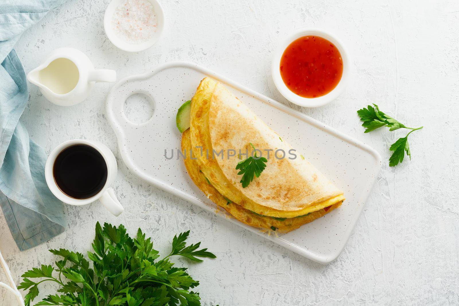 Trendy breakfast with quesadilla and eggs, trending food with omelet, cheese, peppers, tomatoes, avocado. Simple and easy lunch