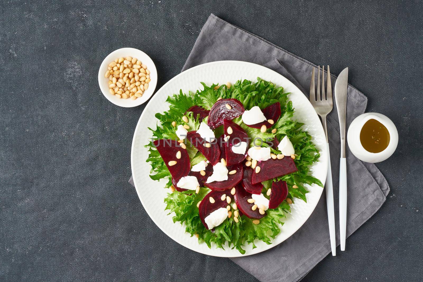 salad with beet, curd, feta, ricotta and pine nuts, lettuce. Healthy keto ketogenic dash diet, dark table, top view