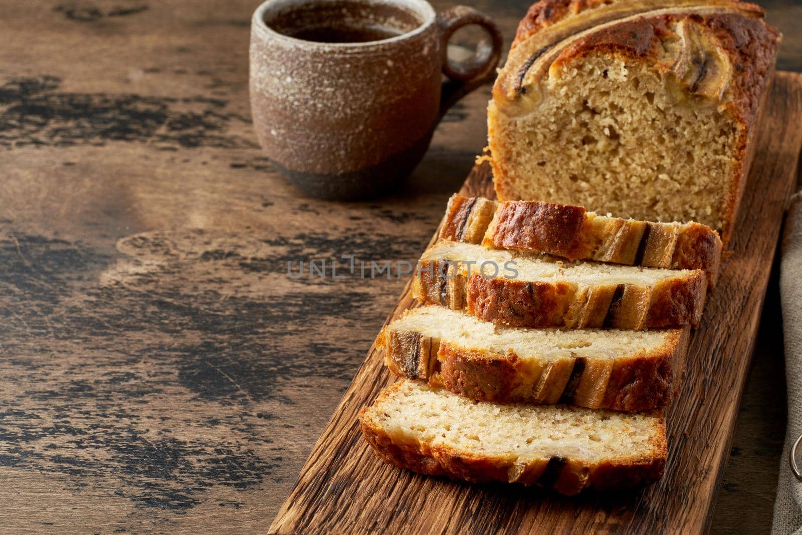 Banana bread. Cake with banana, traditional american cuisine. Slices of loaf. Dark background, black table. Copy space