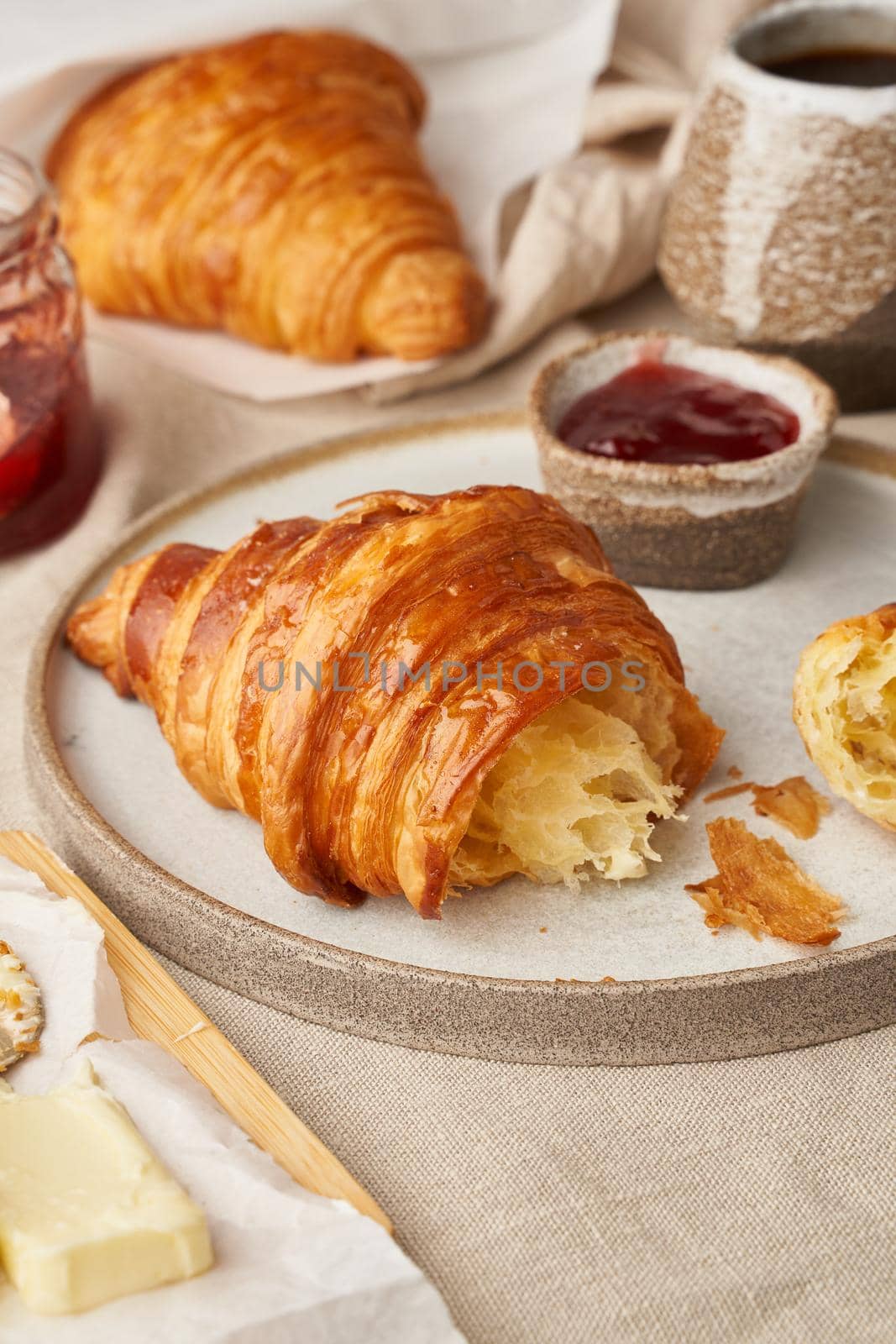 Two delicious croissants on plate and hot drink in mug, side view, vertical by NataBene