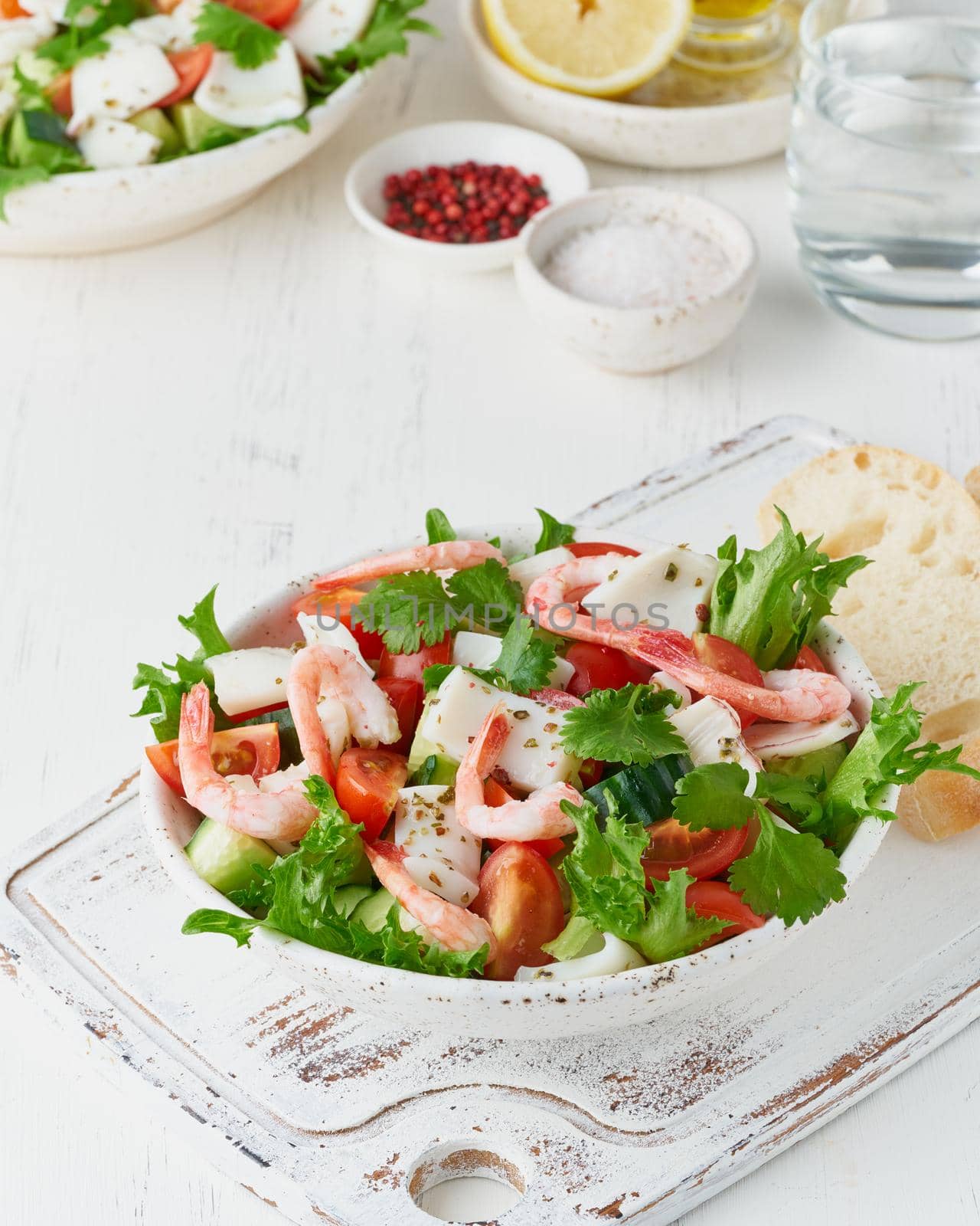 Seafood salad with squid, shrimp, cucumbers, tomatoes and lettuce. LCHF, FODMAP, paleo diet by NataBene