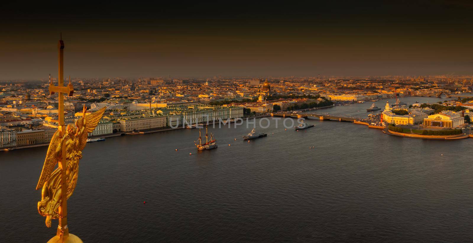 The golden angel on the cross of the Peter and Paul Fortress at sunrise, landmarks of St. Petersburg on background, Isaac cathedral, Admiralty, Rostral columns, Winter Palace. High quality photo