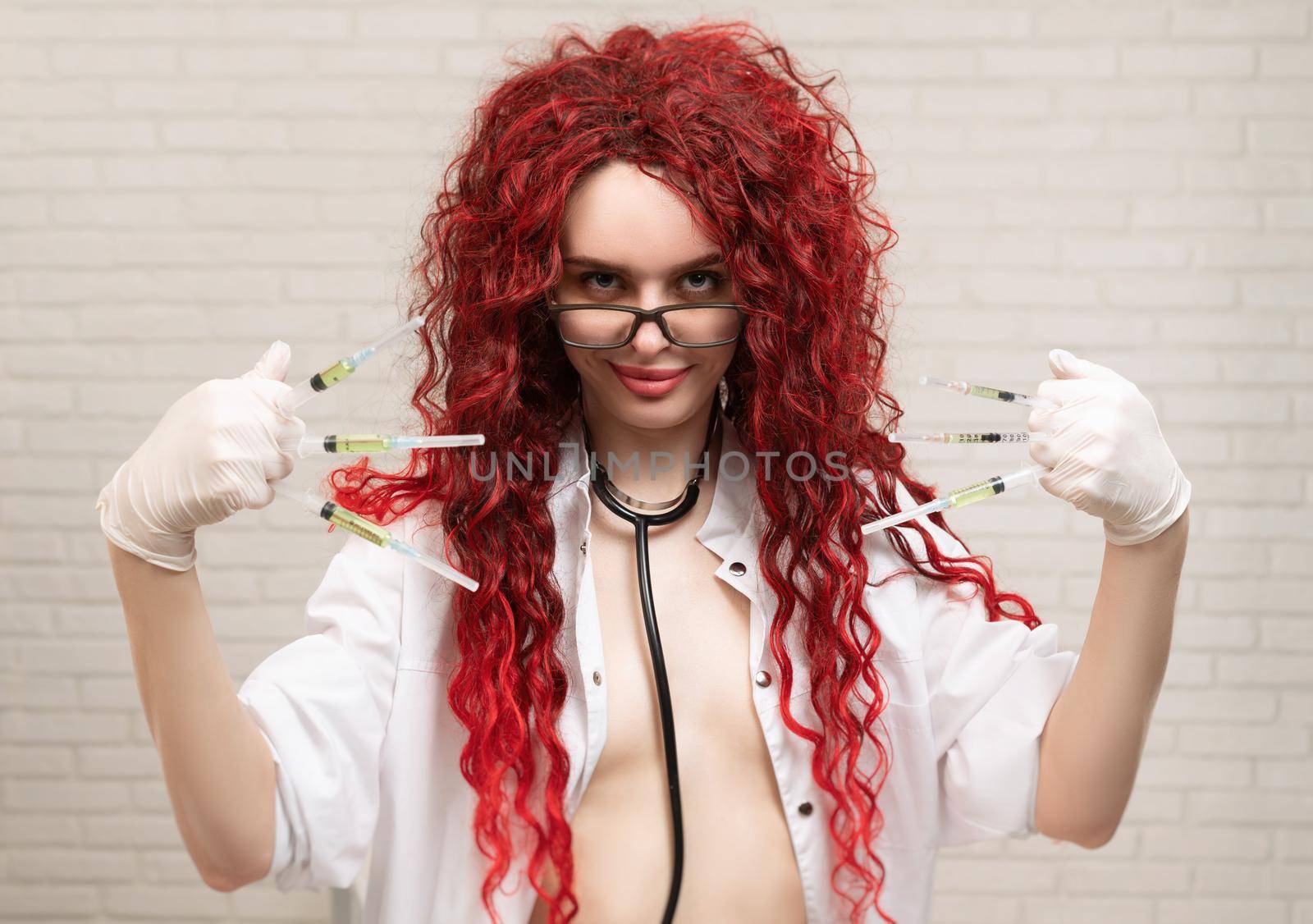 the sexy portrait of a nurse girl with vaccination syringes in her hands
