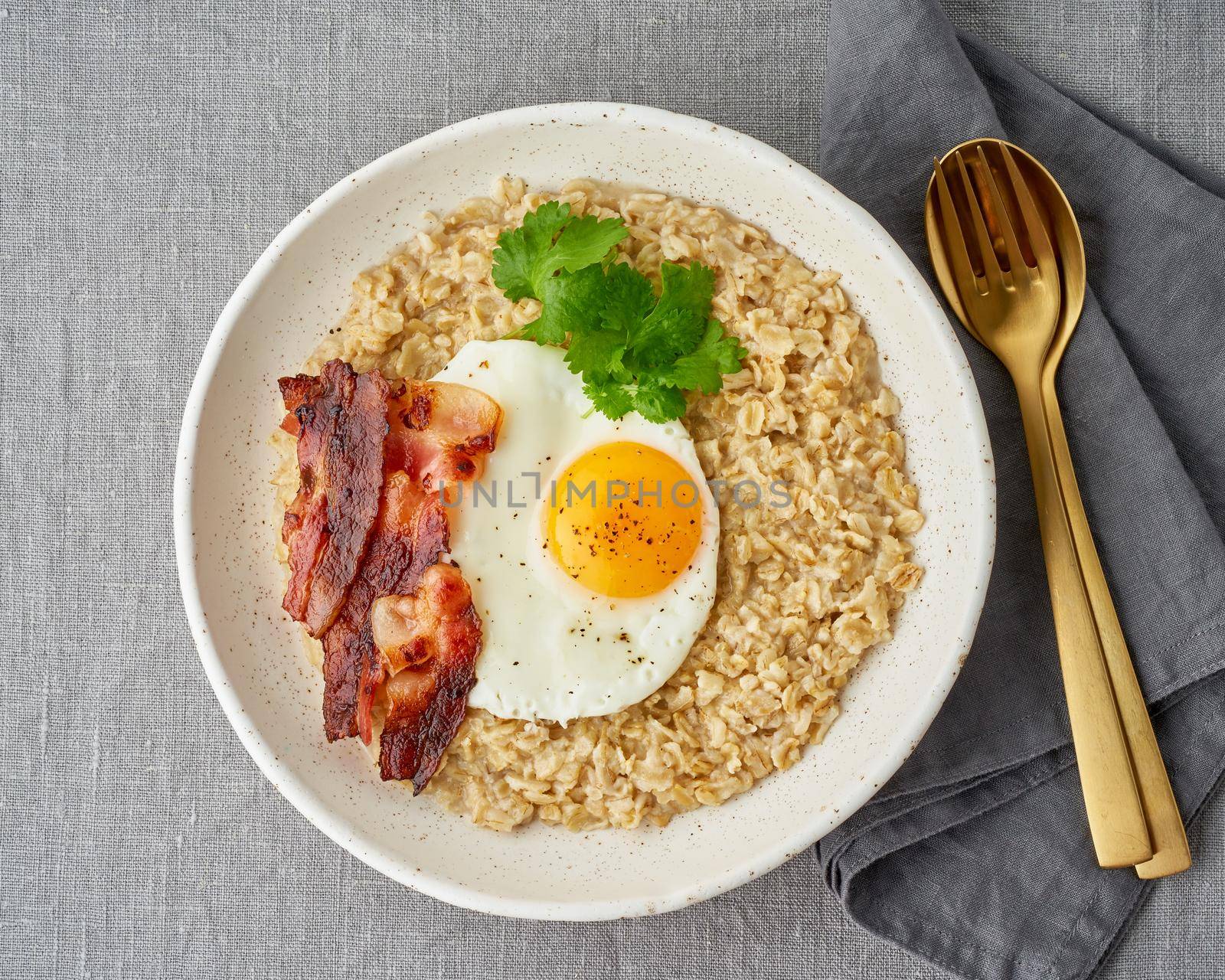 Oatmeal, fried egg and fried bacon. Hearty fat high-calorie breakfast, source of energy. Balance of proteins, fats, carbohydrates. Balanced food, clean eating. Intuitive conscious food. Lactose free