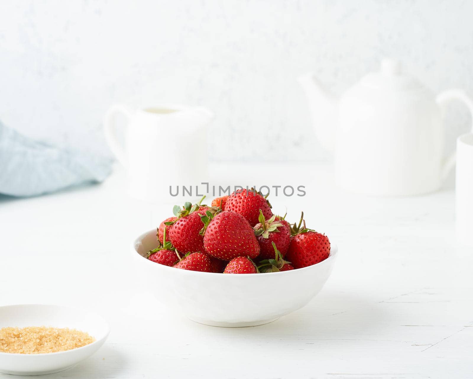 Strawberries in white bowl, on white table, morning Breakfast, summer food, light background