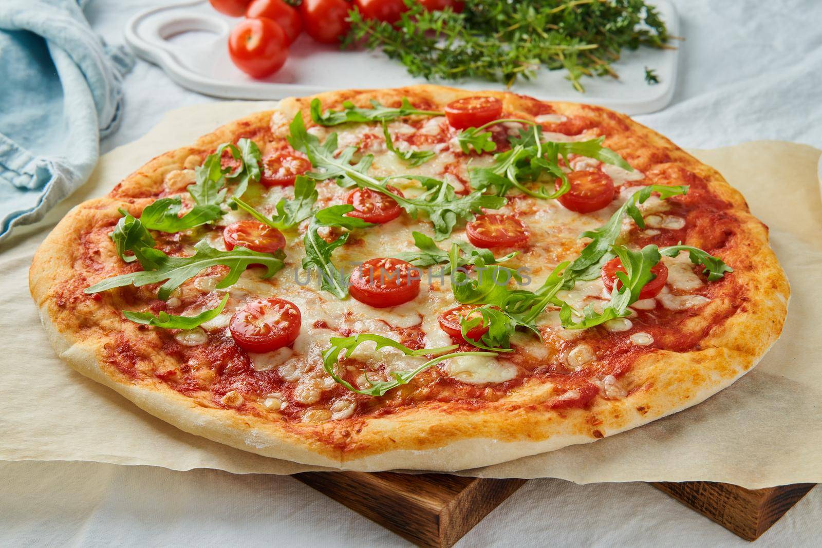 Rustic Italian homemade Pizza Dough margherita topped with pizza sauce from canned tomatoes, mozzarella cheese and arugula, side view