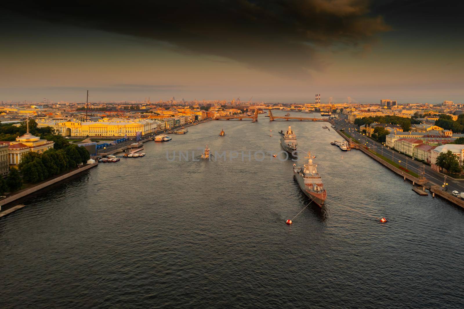 Aerial landscape with warships in the Neva River before the holiday of the Russian Navy at early morning, warships pass under a raised drawbridge, the latest cruisers among landmarks, Palace bridge. High quality photo