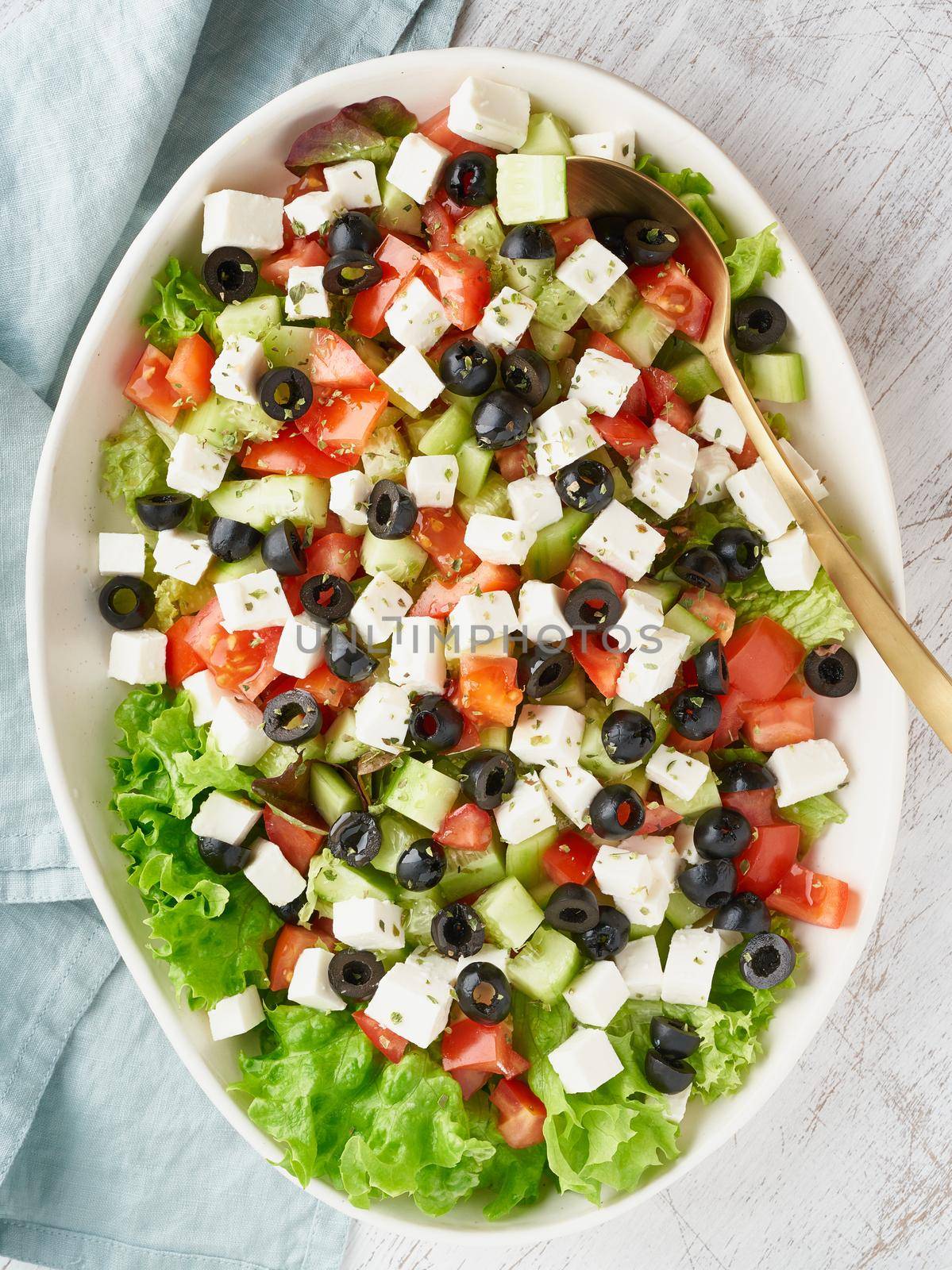 Greek salad Horiatiki with feta cheese, olives, tomato, cucumber, lettuce, vegeterian mediterranean food, low calories dieting meal, vertical