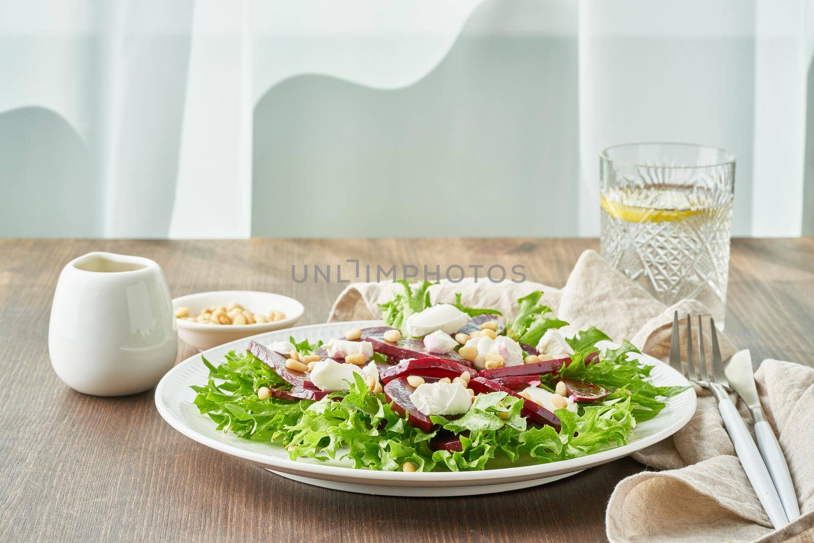 salad with beet, curd, feta, ricotta and pine nuts, lettuce. Healthy keto ketogenic dash diet, dark table, side view