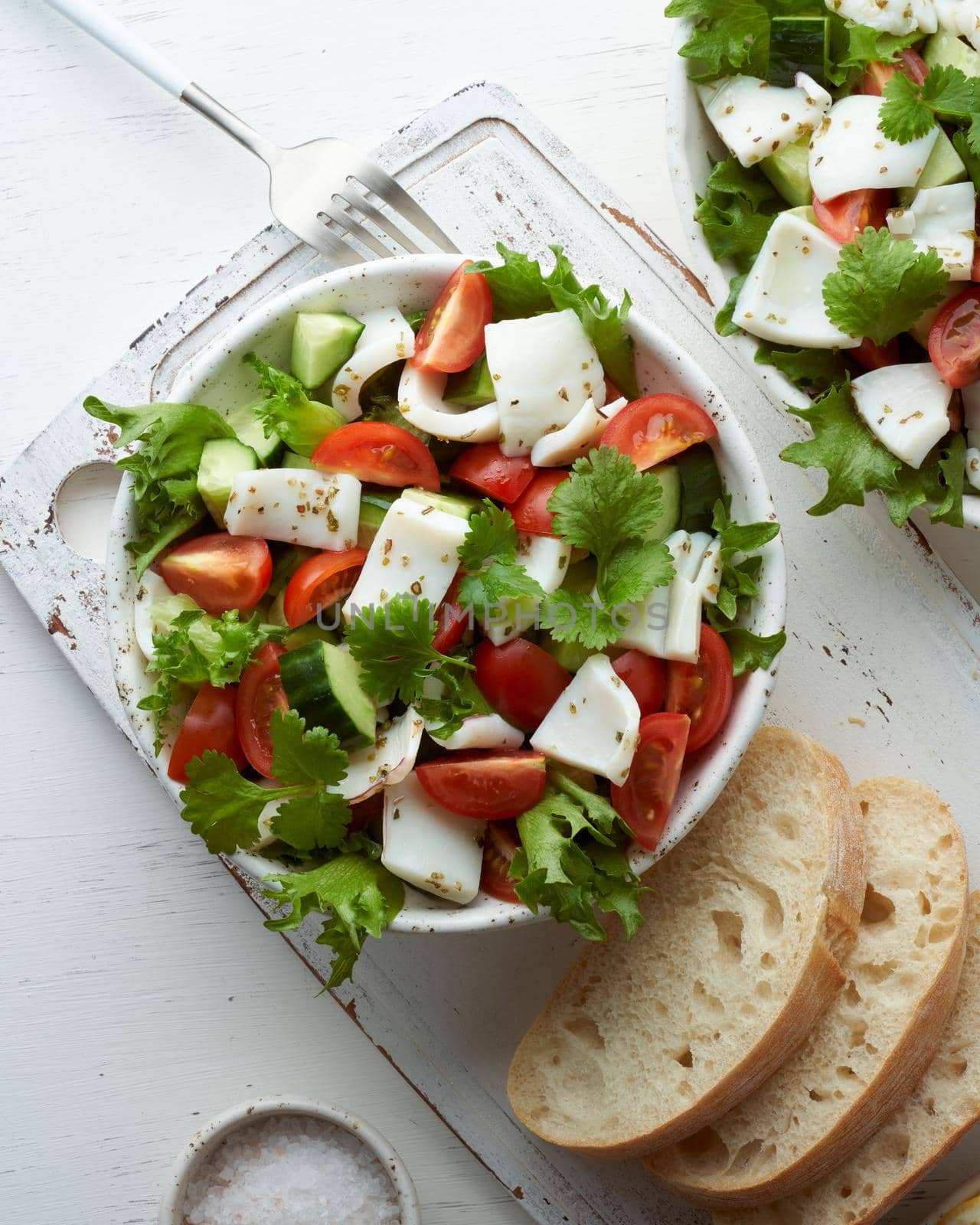 Salad with squid, cucumbers, tomatoes and lettuce. LCHF, FODMAP, paleo diet. Fresh spring vitamin mix. Healthy Mediterranean food, balanced food. Top view, vertical