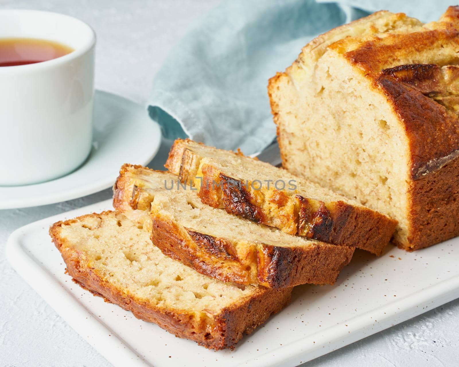 Banana bread. Cake with banana, traditional american cuisine. Slice of loaf. Gray background. Side view, close up