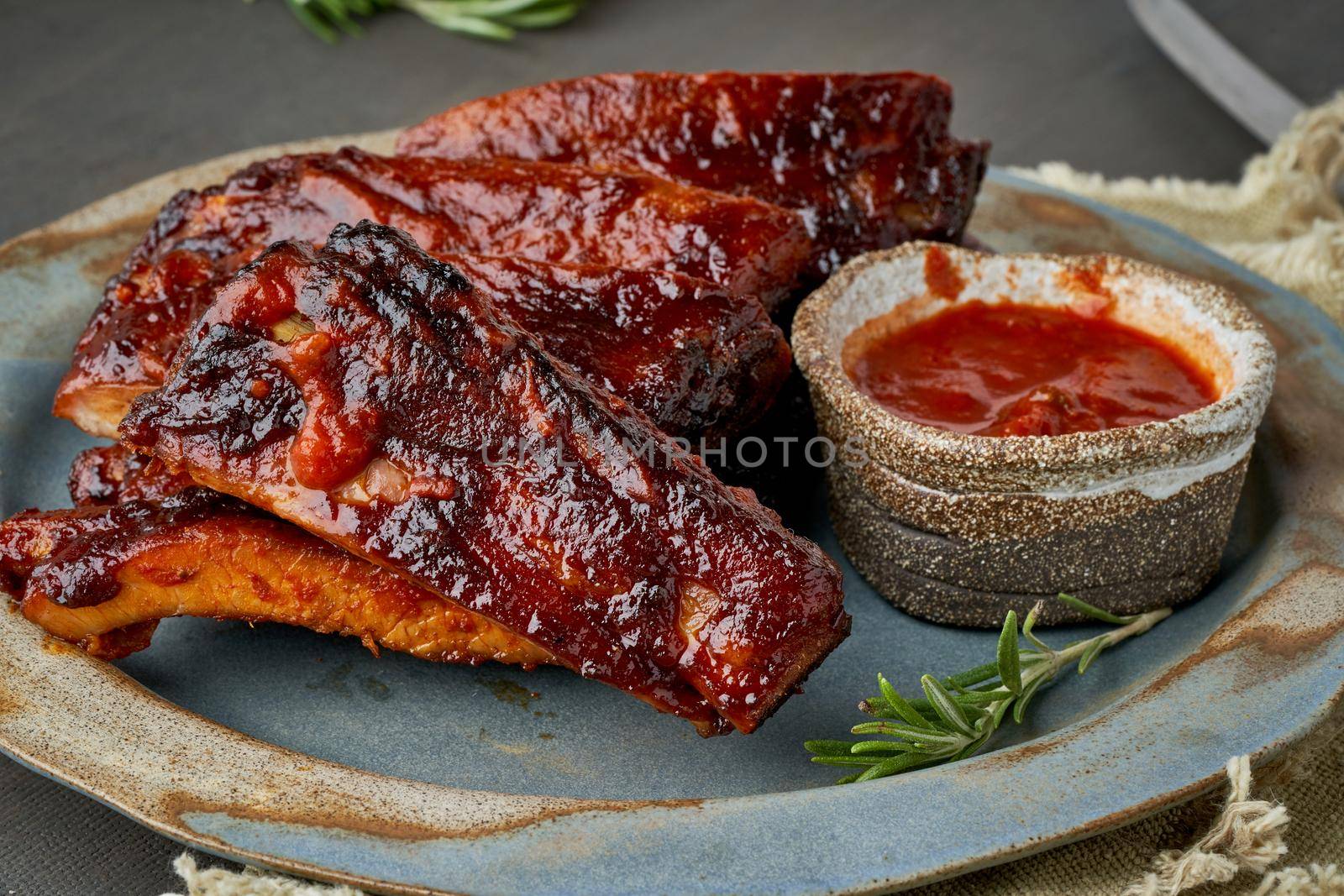 Keto food, barbecue pork ribs. Slow cooking recipe. Pickled Roasted Pork Meat with red sauce. Asian Cuisine, Korean. Side view, close up