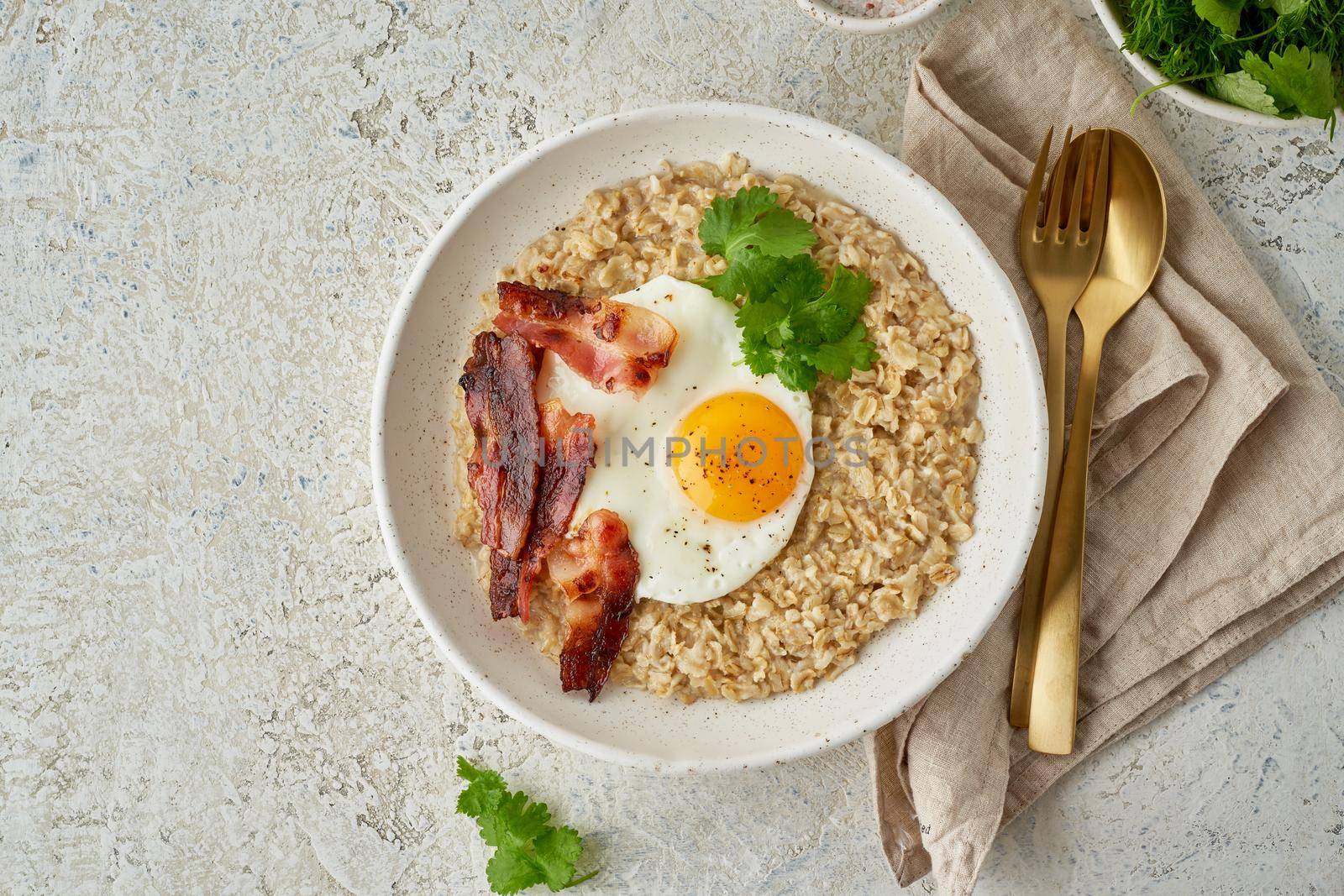 Oatmeal, fried egg, fried bacon. Hearty fat high-calorie breakfast, source of energy. Balance of proteins, fats, carbohydrates. Balanced food. Intuitive conscious food, top view, copy space