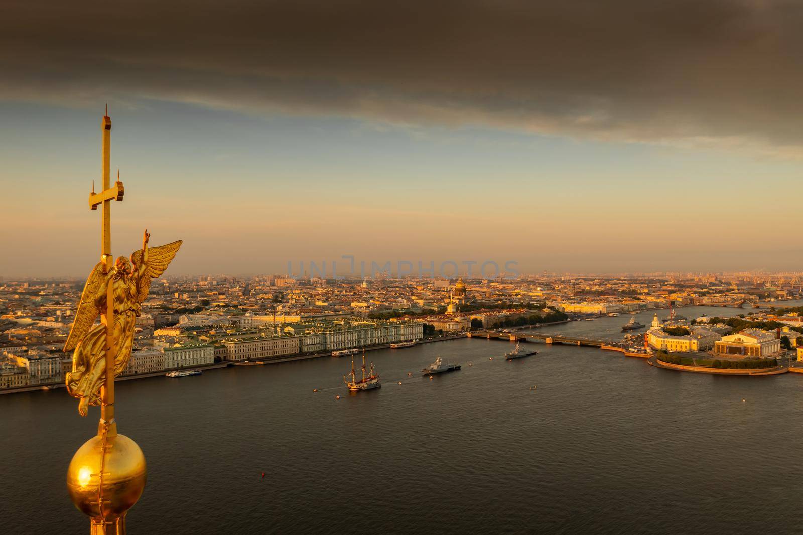 The golden angel on the cross of the Peter and Paul Fortress at sunrise, landmarks of St. Petersburg on background, Isaac cathedral, Admiralty, Rostral columns, Winter Palace. High quality photo