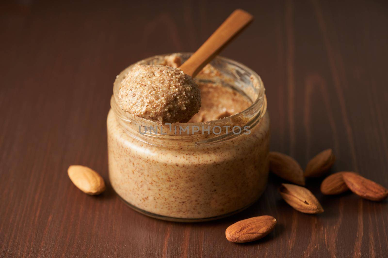 almond butter, raw food paste made from grinding almonds into nut butter, side view by NataBene