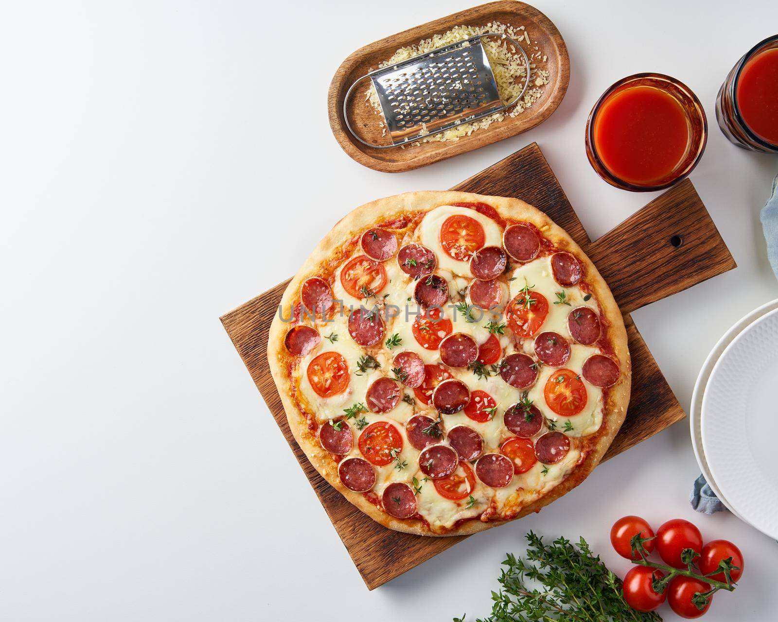 Hot homemade Italian pepperoni pizza with salami, mozzarella on white table by NataBene