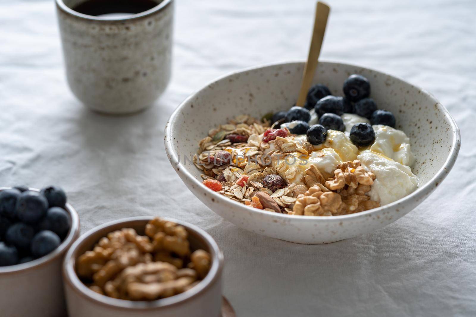 Healthy lifestyle breakfast with granola muesli and yogurt in bowl on white table background by NataBene