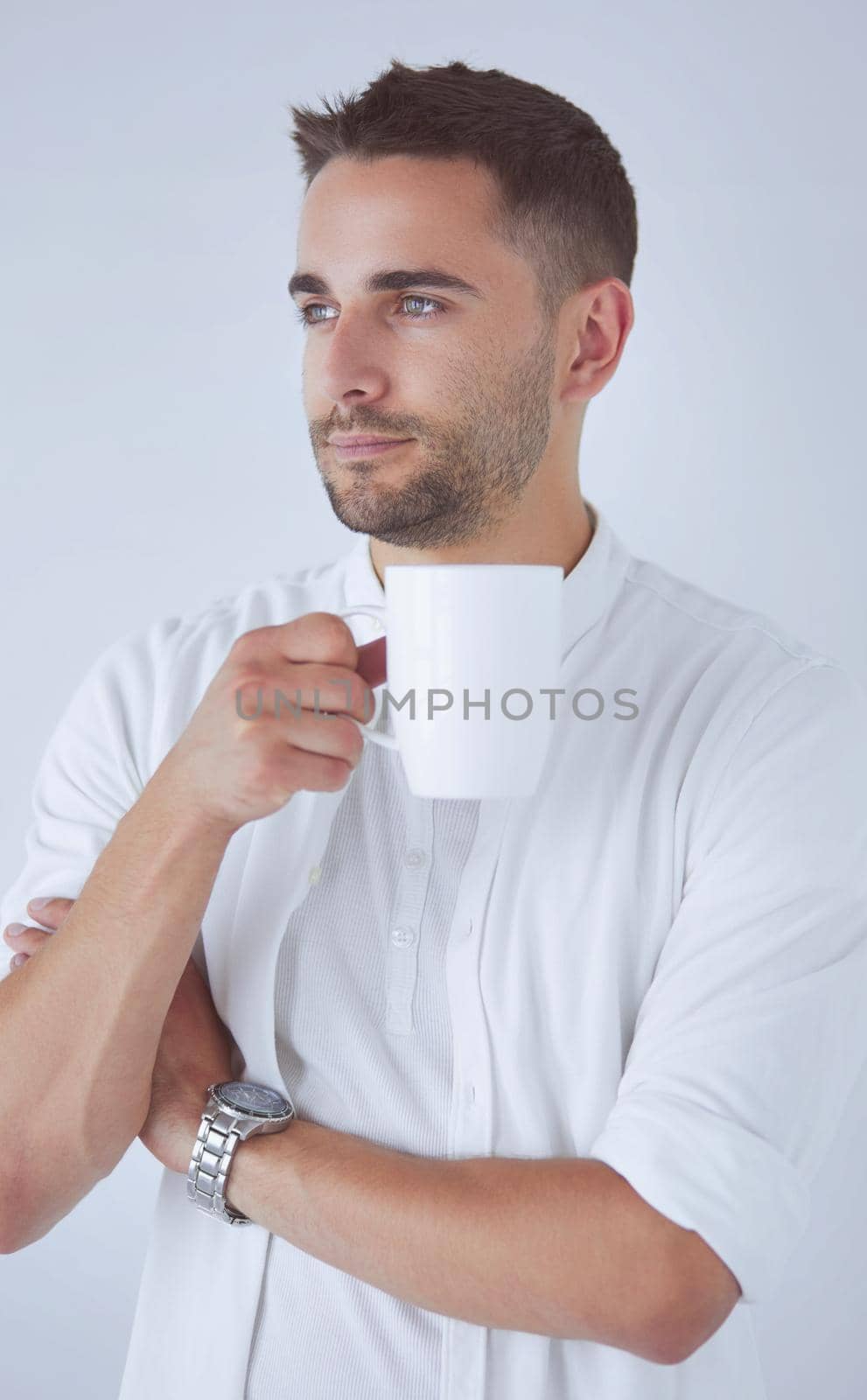 Young business man drinking a cup of coffee or tea.