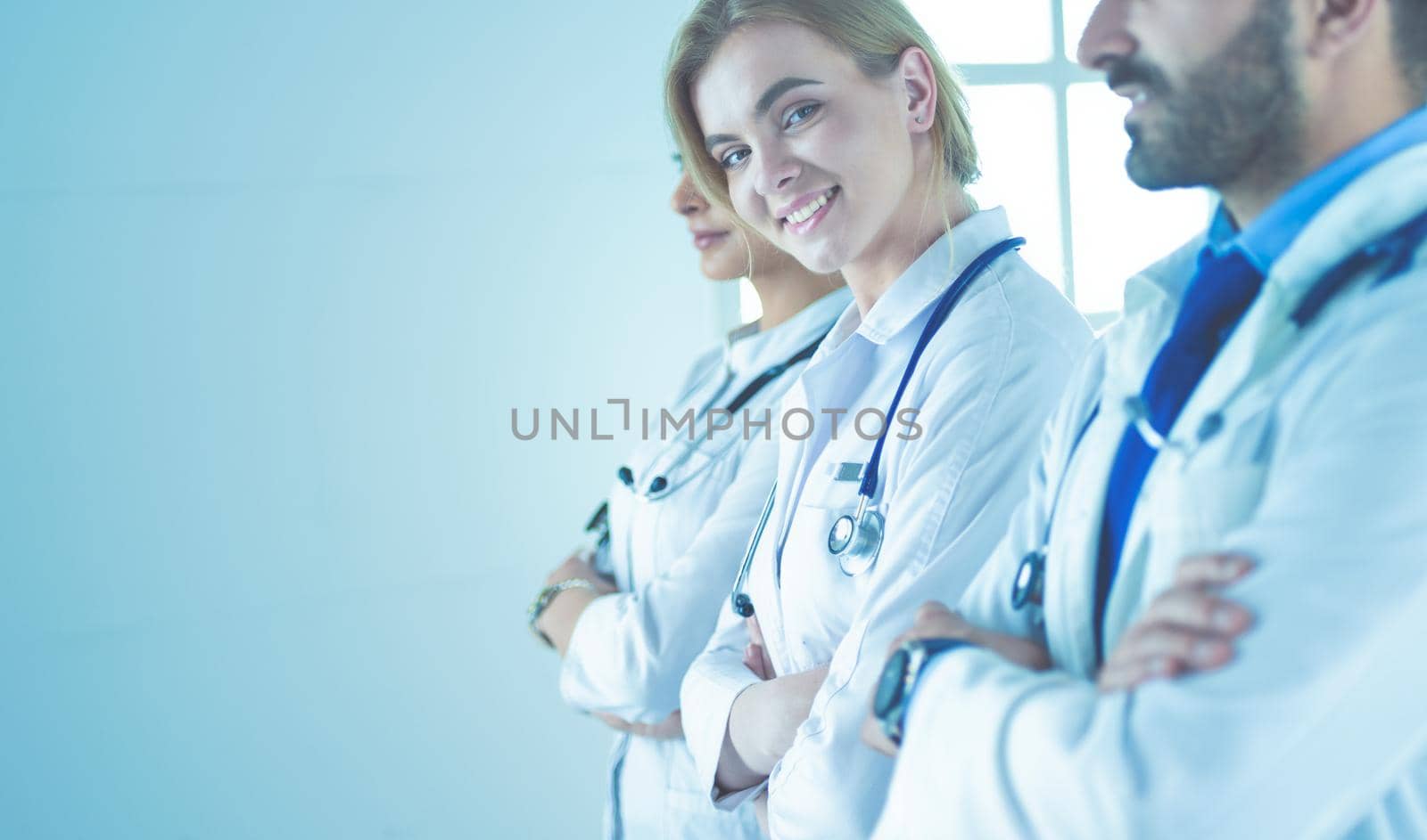 Portrait of confident doctors with arms crossed at medical office.