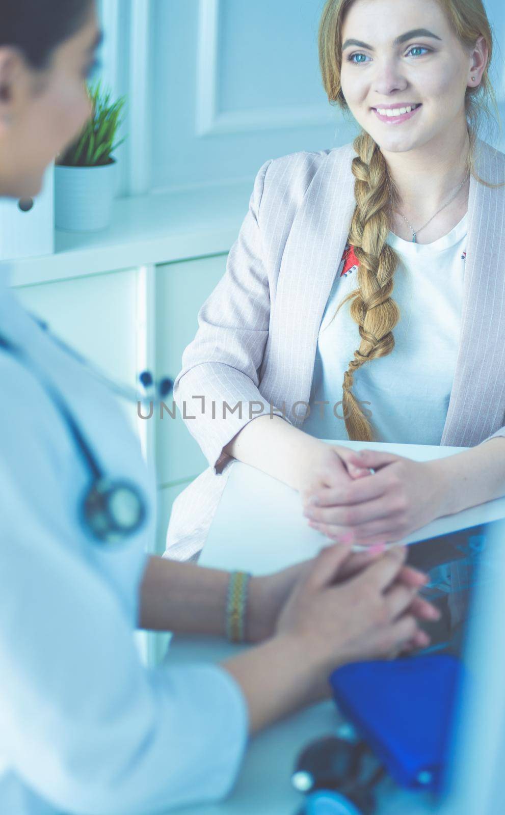Doctor and patient discussing something while sitting at the table . Medicine and health care concept.