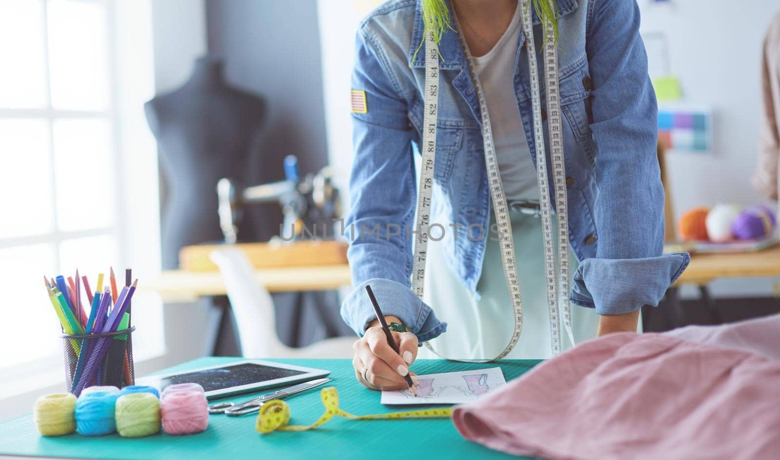Fashion designer woman working on her designs in the studio.