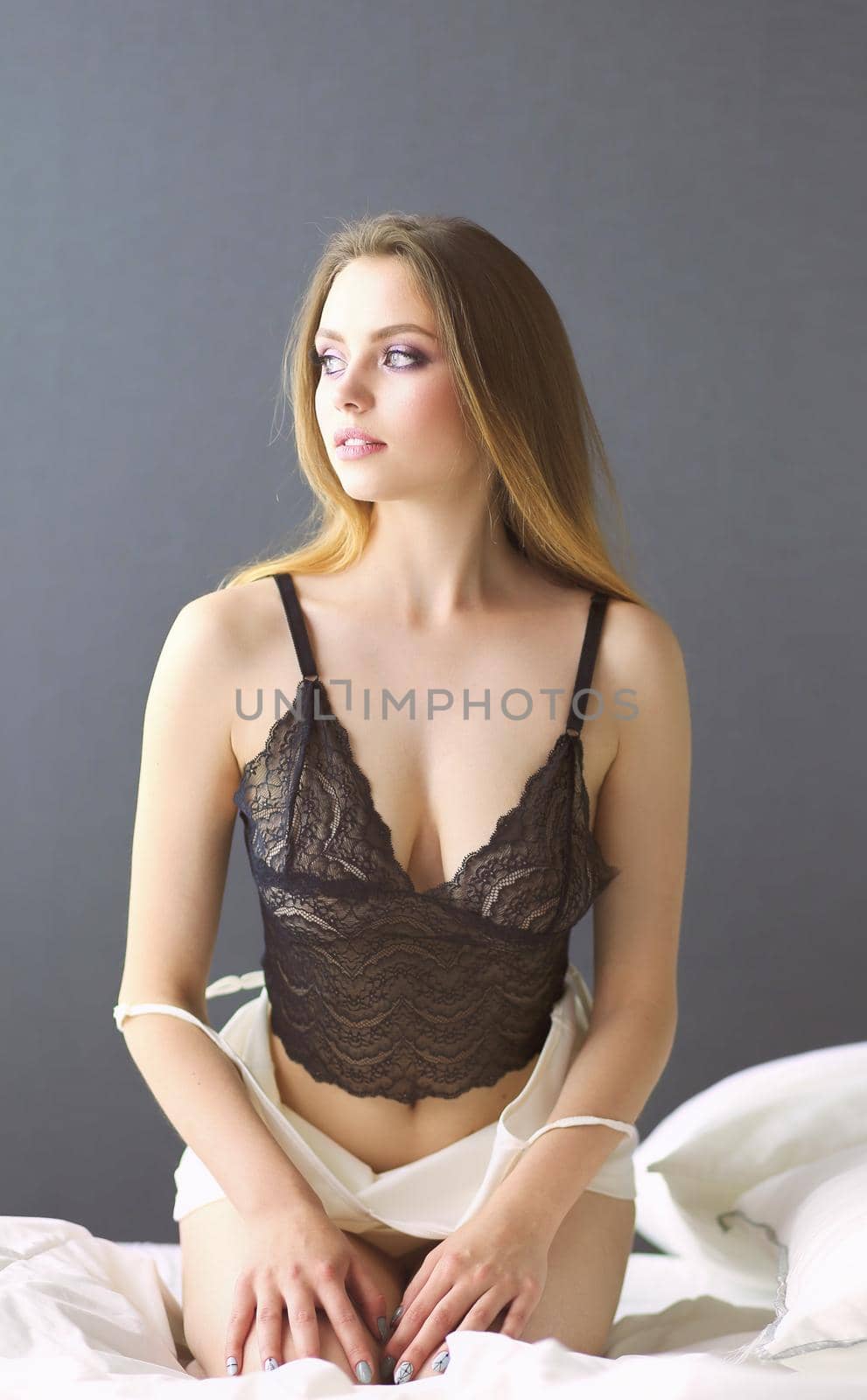Portrait of beautiful young woman in nightwear on bed.