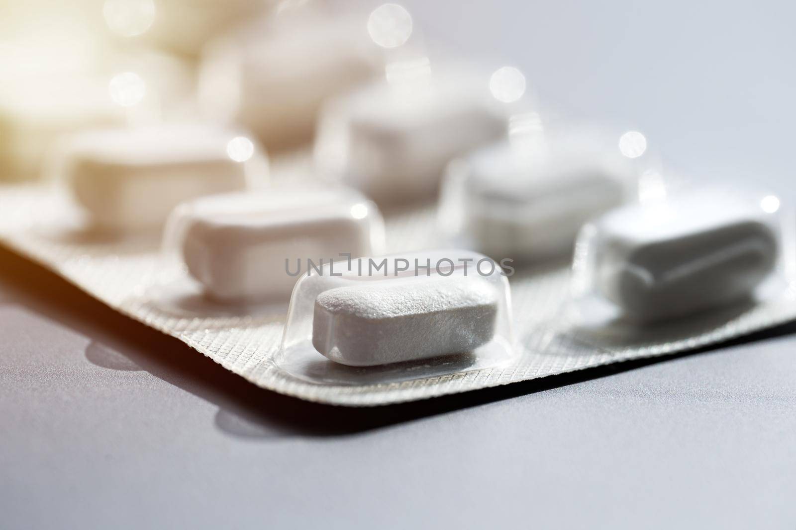 Closeup of pills in blister pack. Headache pills, painkillers, antibiotics or antidepressants tablets by DariaKulkova