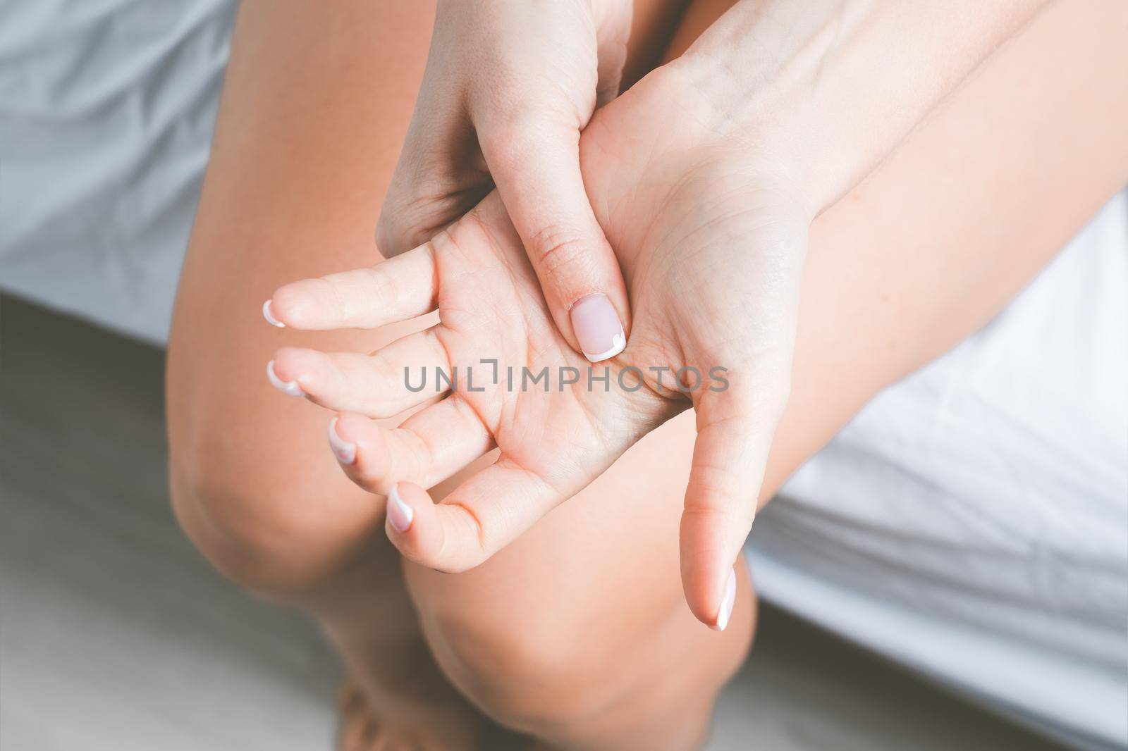 Woman suffering from hand pain or finger pain. Hand numbness or limb numbness after sleep. Massaging painful hand. High quality photo