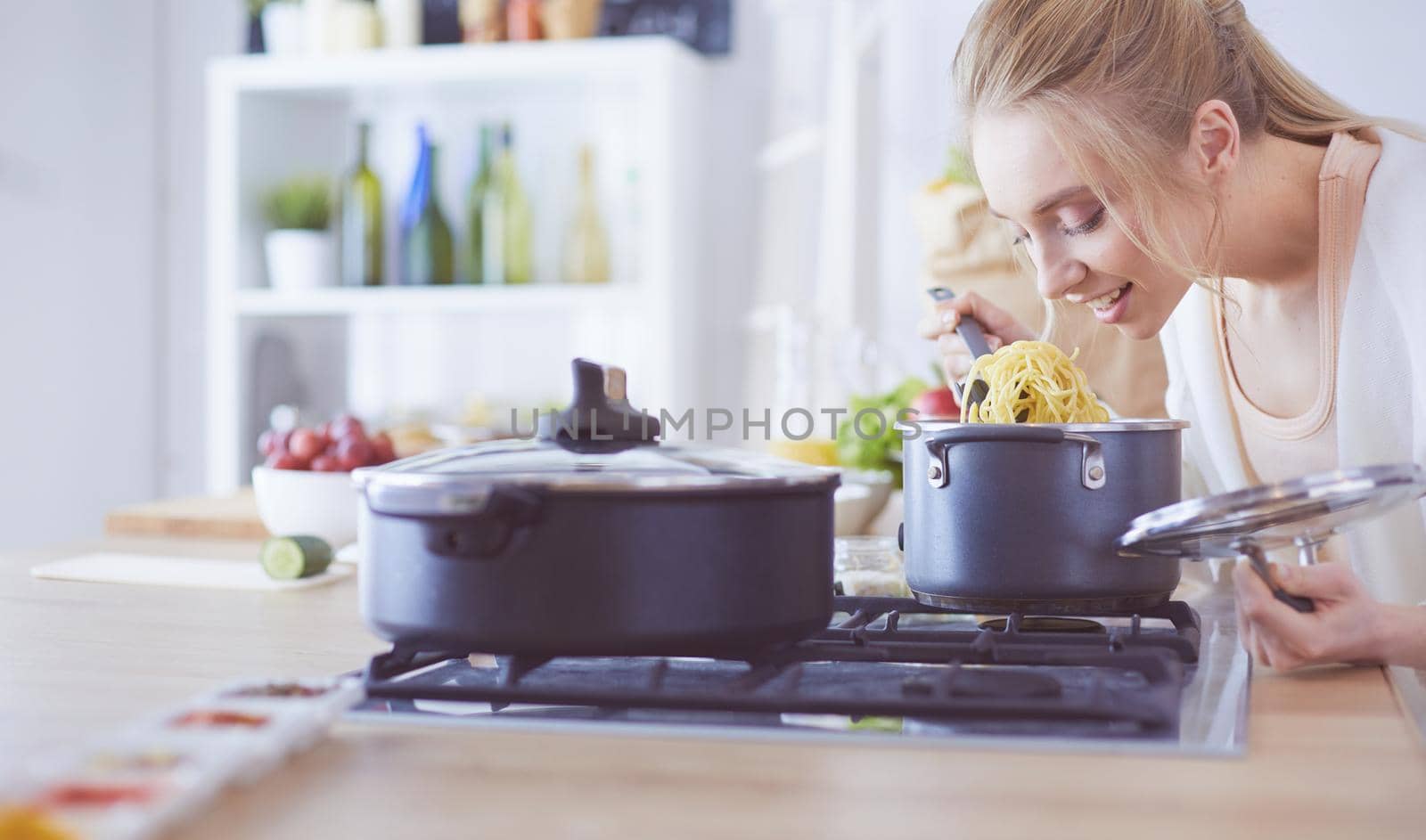 Beautiful young woman cooking in kitchen at home.