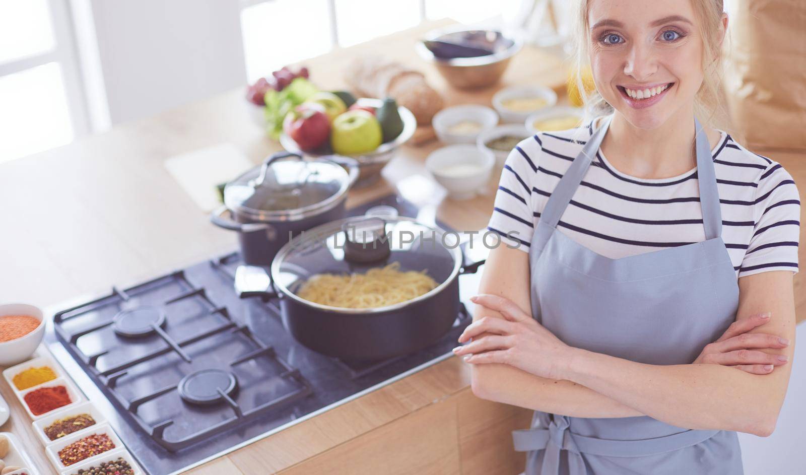 Young woman standing near desk in the kitchen .