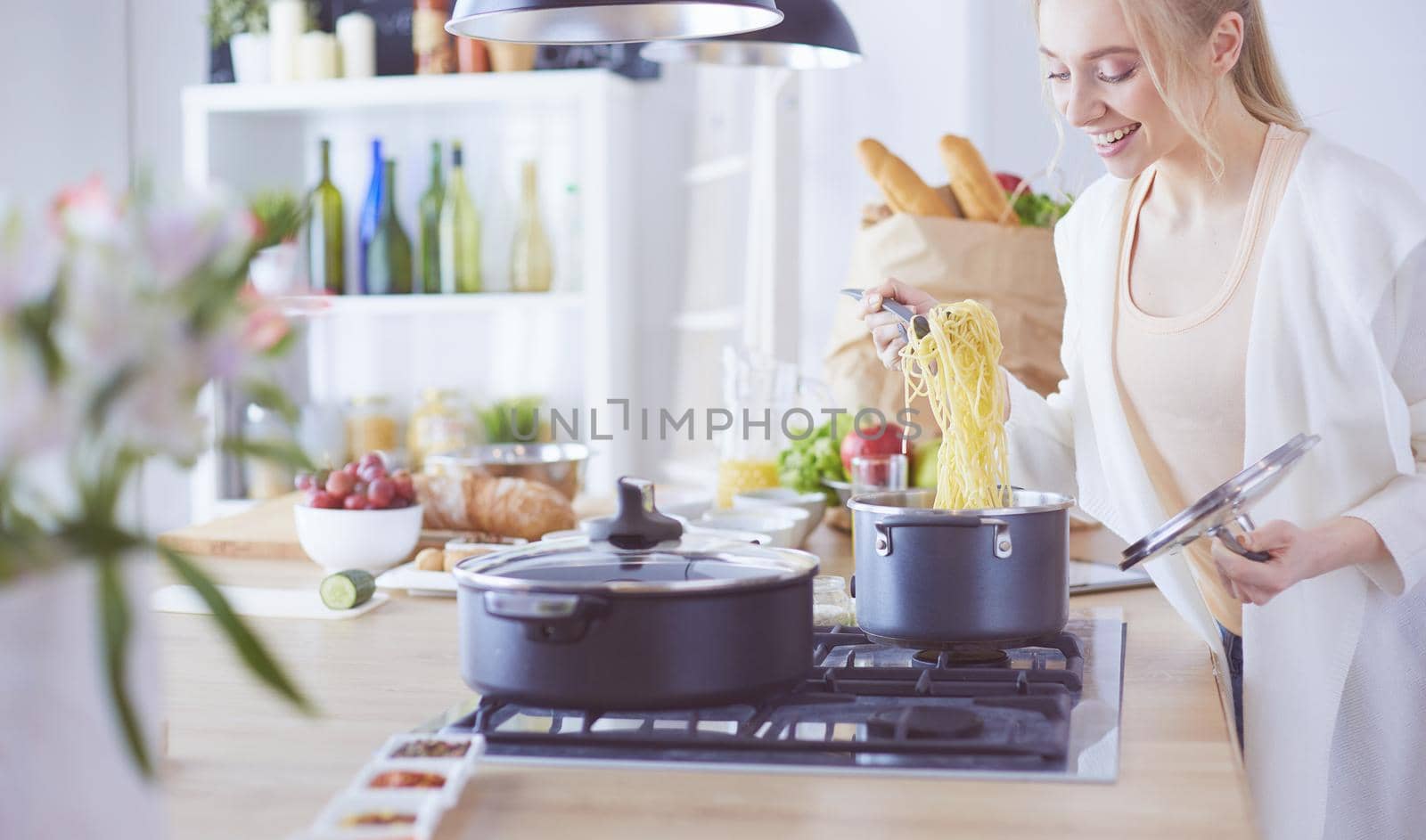Beautiful young woman cooking in kitchen at home.