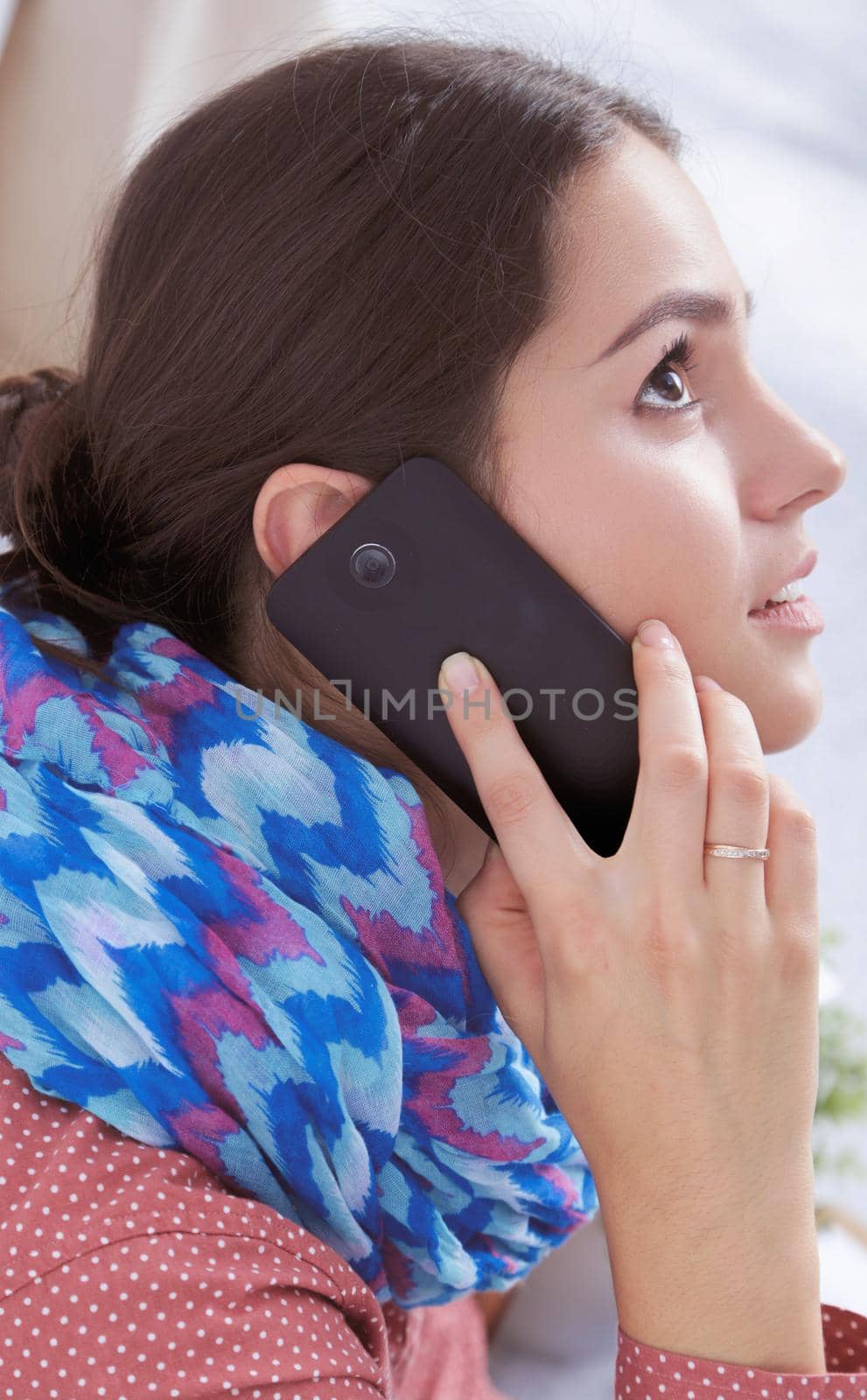 Beautiful young woman talking on smart phone .