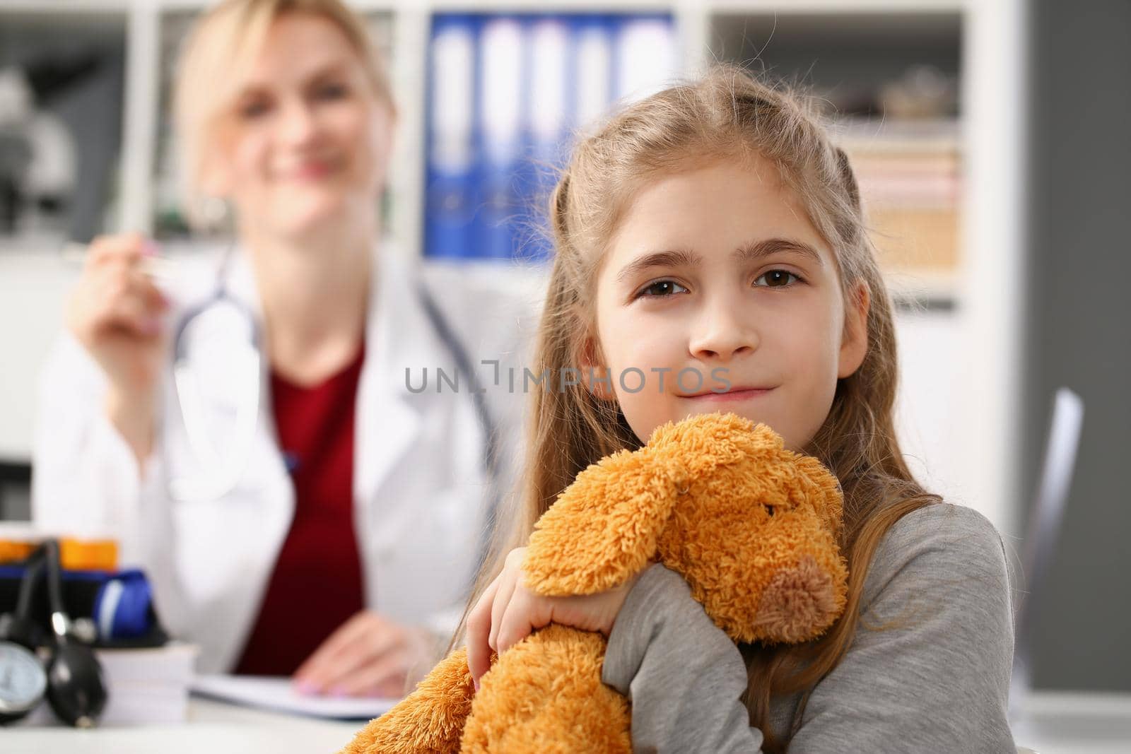 Portrait of cute smiling child at pediatrician, kid hug teddy bear favourite toy. Healthy lifestyle, sickness, clinic test, childhood, diagnostic concept