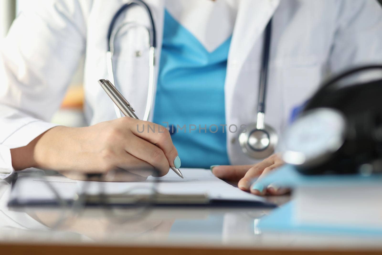Close-up of doctor fill patient illness history or prescribe medication for client, busy doctor. Qualified medical worker in clinic. Healthcare concept