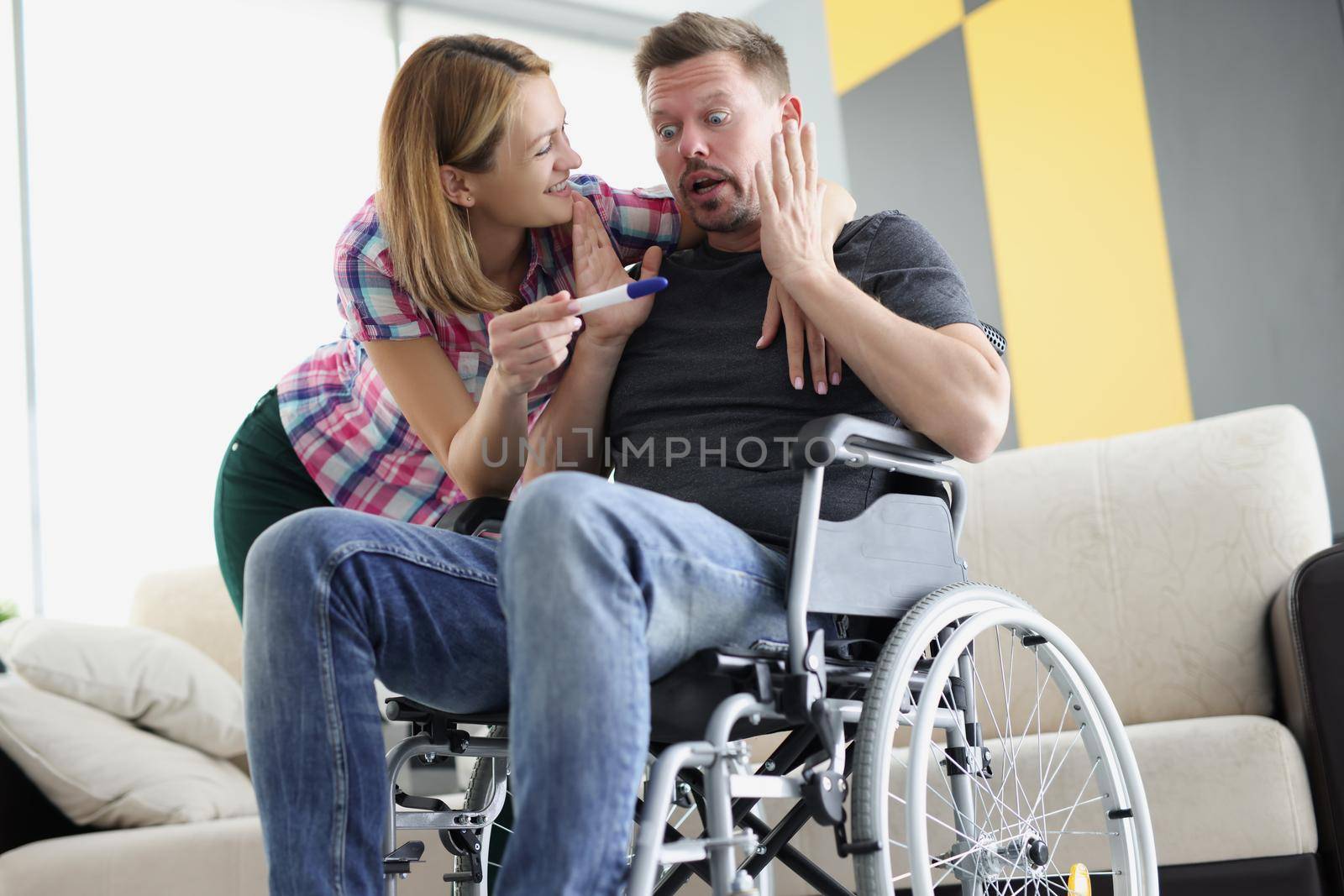 Surprised husband got news about wife pregnancy, middle aged man in wheelchair by kuprevich