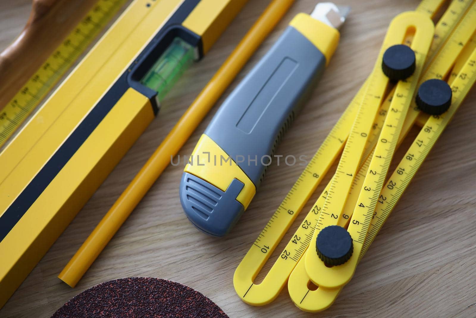 Close-up of workers set of instruments, box cutter, level, ruler equipment on wooden table. Construction, builder, renovation, carpenter, tool kit concept