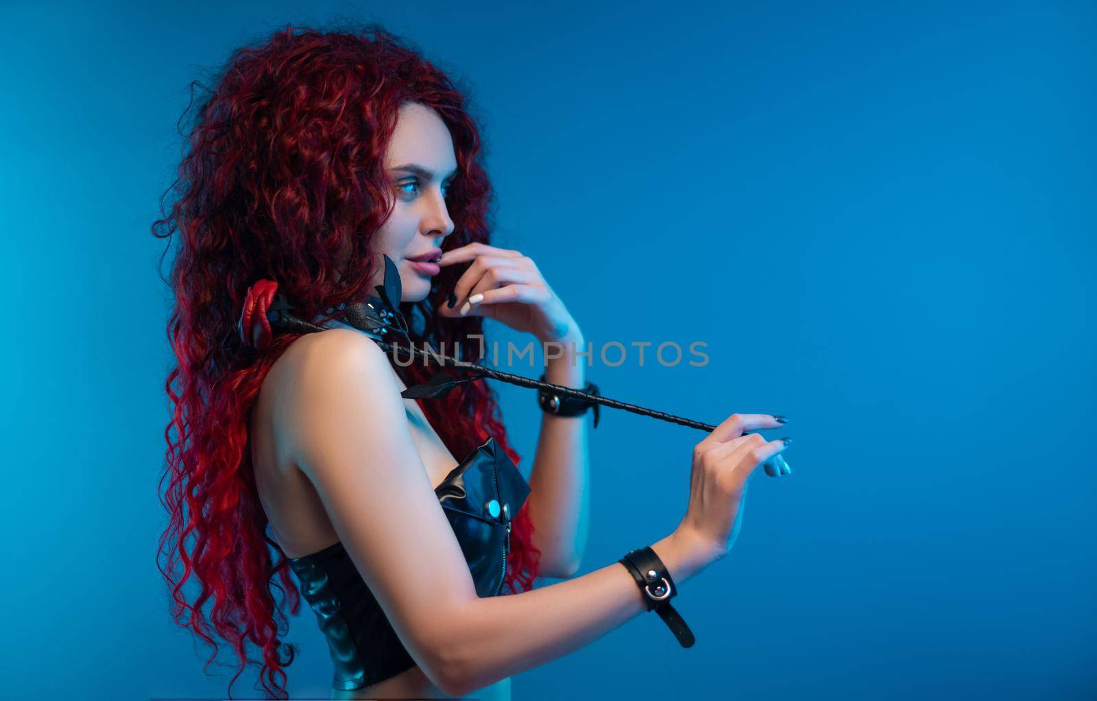 portrait of a girl with a chic hairstyle and red hair with a leather rose in her hands by Rotozey