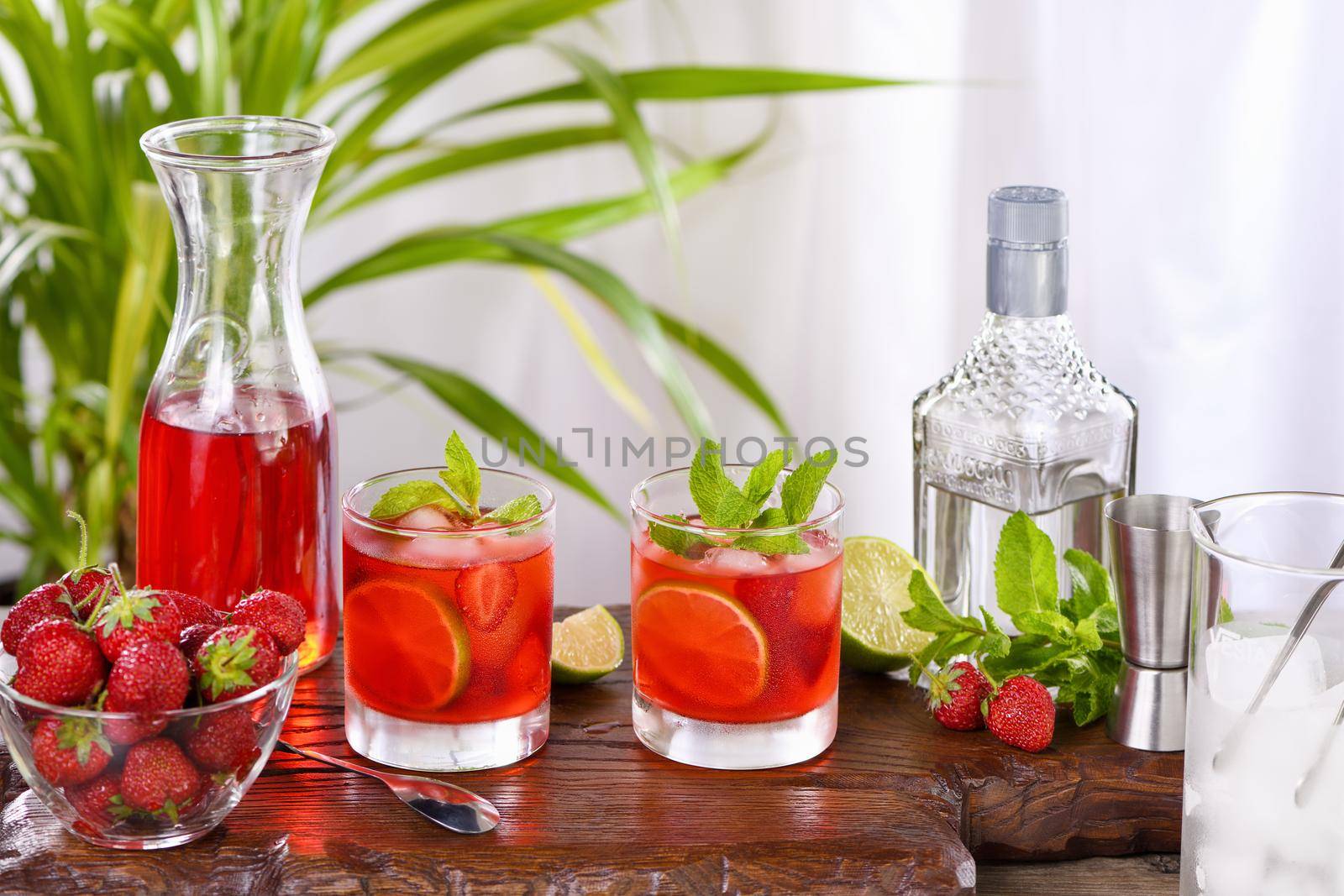 Refreshing cocktail strawberry mojito with ice, fresh mint and lime. A great idea for a picnic or summer party. It may contain alcohol or be a mocktail.