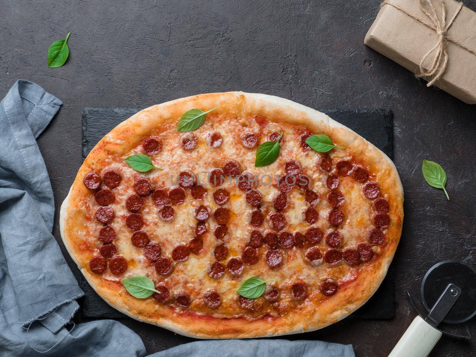 Father's day background. Pepperoni pizza with i love dad lettering and gift box on black table. Father day concept, recipe and idea. Top view or flat-lay. Copy space for text.