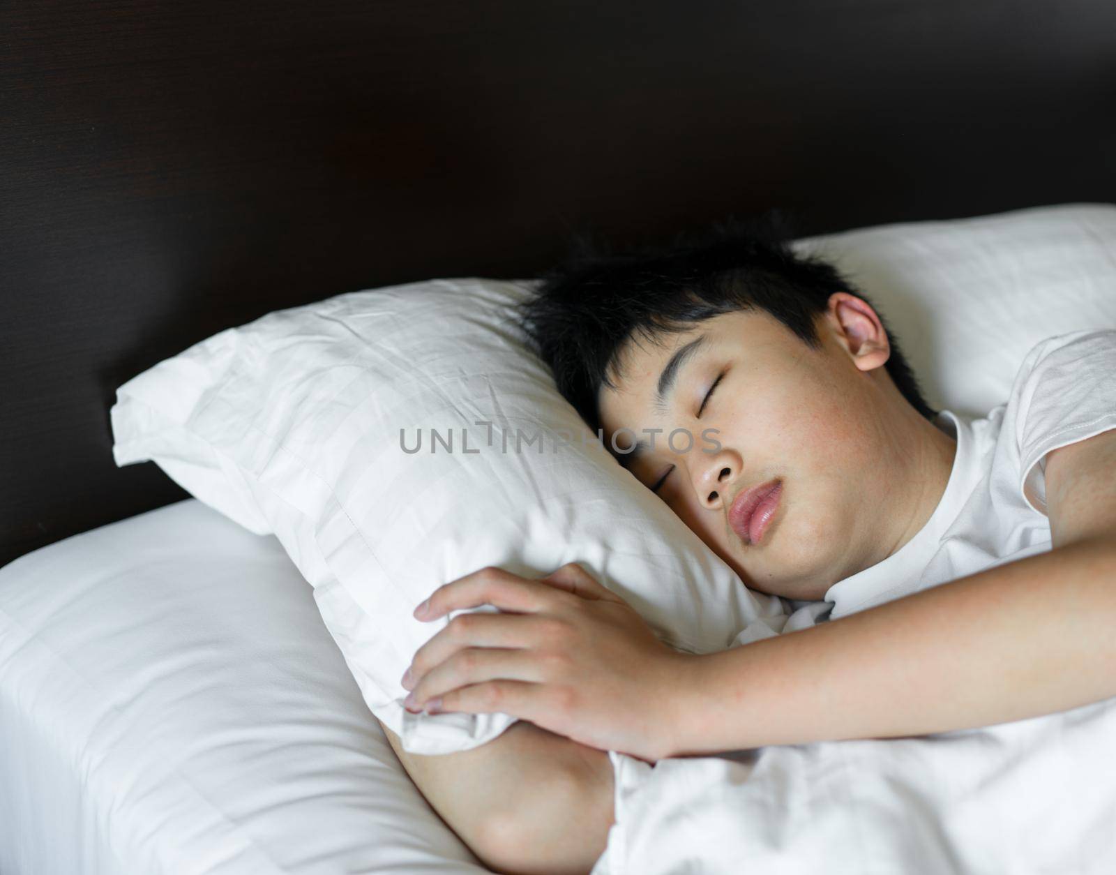 A boy sleep on bed at bedroom.  Relax and healthy concept